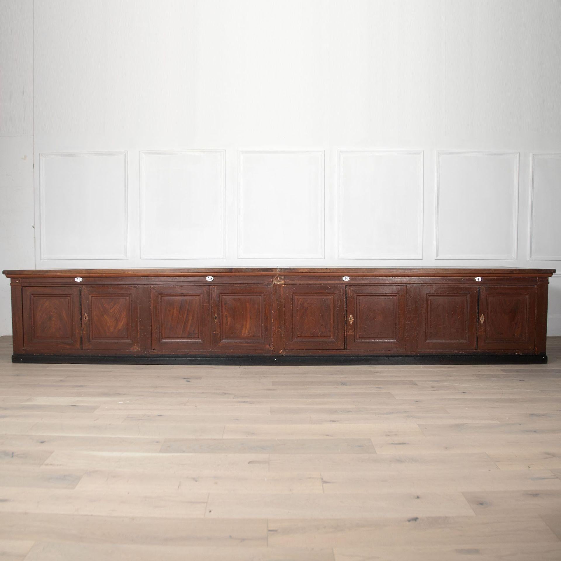 A very large and important 19th Century French counter in walnut. 
This is a freestanding item with cupboards both sides and eight doors on each side. Finished all the way around with a stunning original top. 
This is an extremely rare item to find