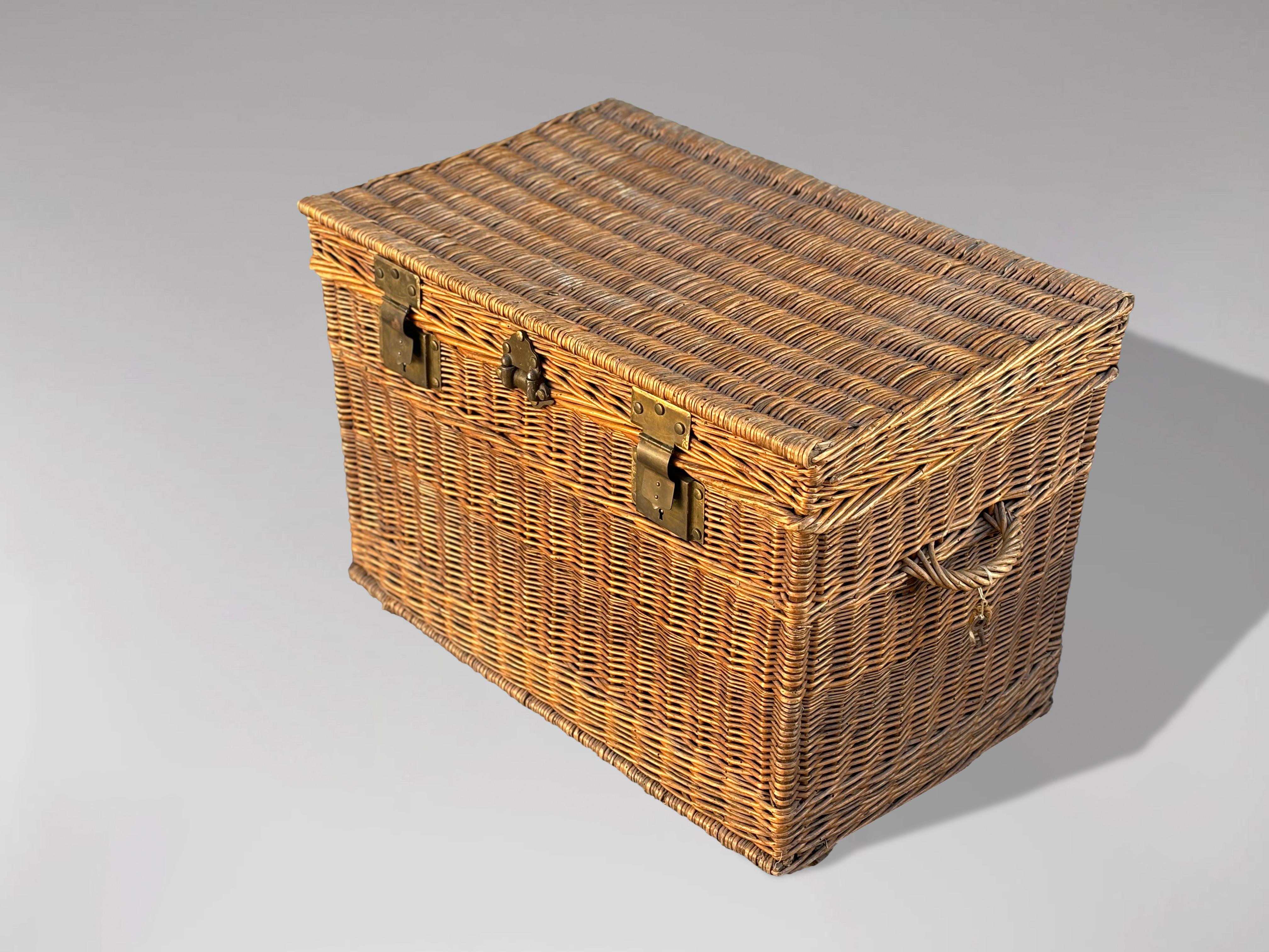 This large late 19th-century French woven willow wicker trunk features a lid, two brass locks with the original key, and two wicker handles. The brass locks are marked with the name 