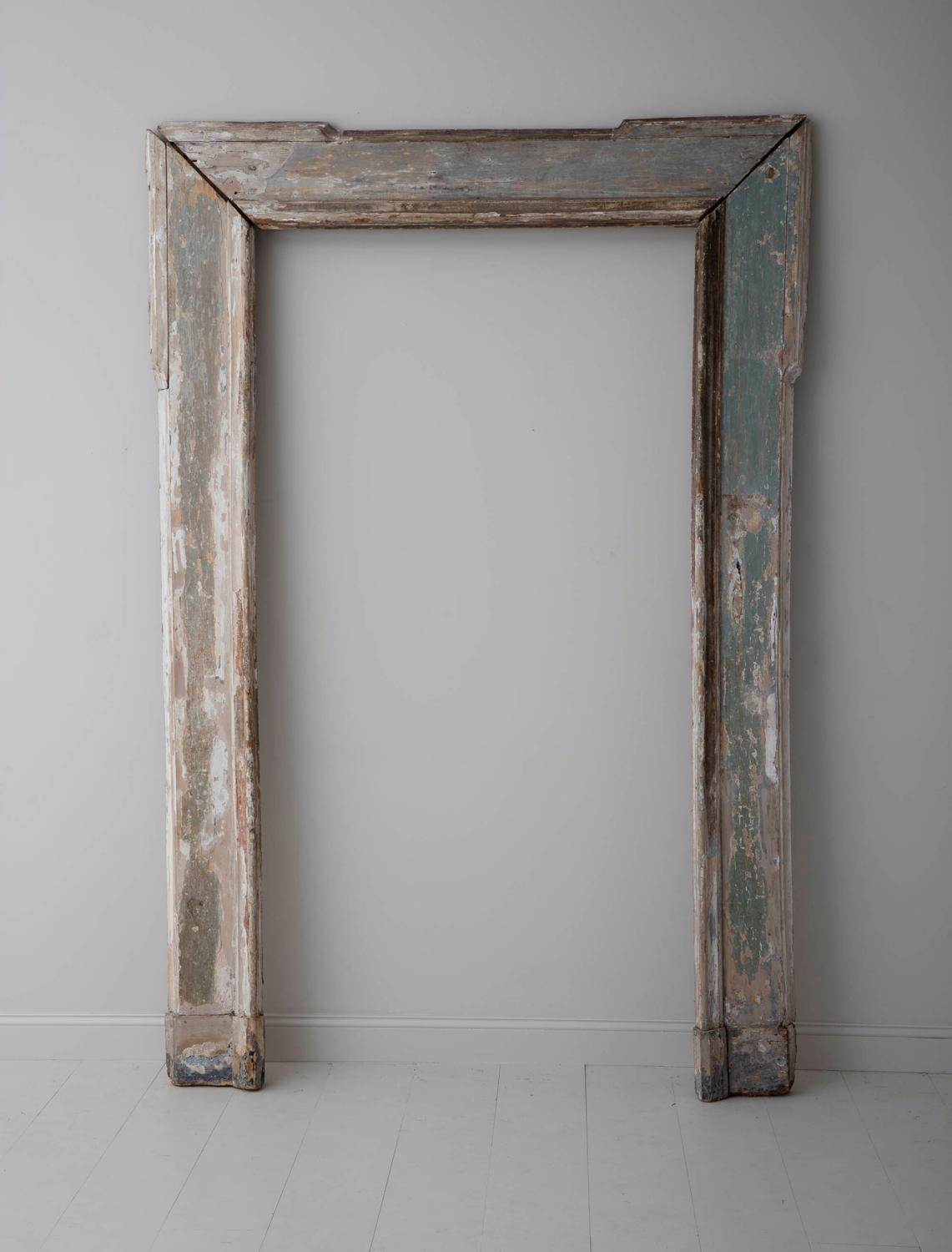 An impressive French architectural wood frame most likely used to frame a mirror. This piece features original paint in a soft, Provençal pale green wearing to reveal natural wood. This would be a lovely piece to frame a mirror or simply to provide
