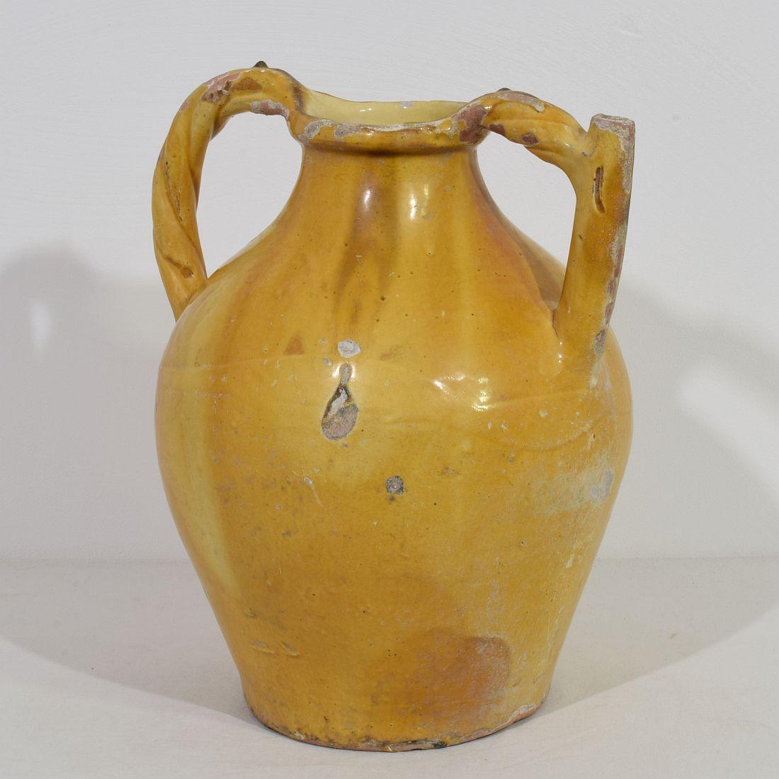 Grande pièce authentique et rarissime de poterie avec un bec en anse provenant de la Provence appelée : Orjol du Lauragais. Le fait que cette cruche ait des anses torsadées la rend encore plus spectaculaire et rare. Magnifique glaçure jaune altérée.