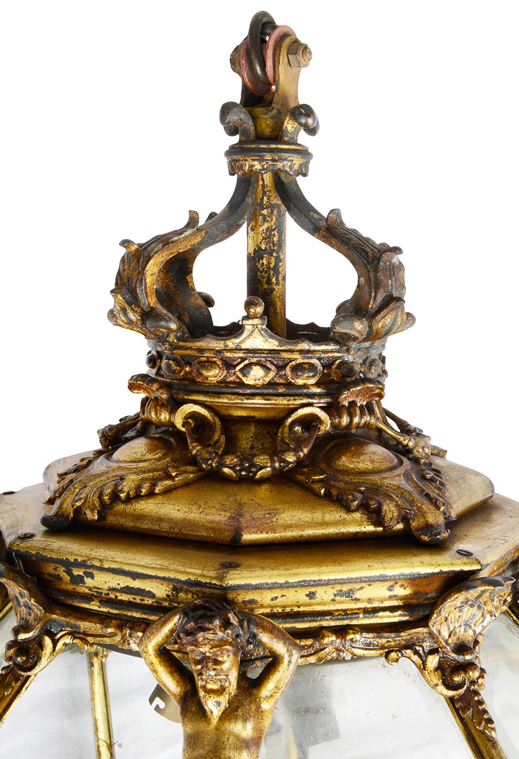 A very good quality 19th century French gilded ormolu hexagonal tapering lantern, having a crown coronet, sea shell and Neptune mounts, beveled glass panels, tapering down to a scrolling ormolu foliate finial. Measures: 98cm(39