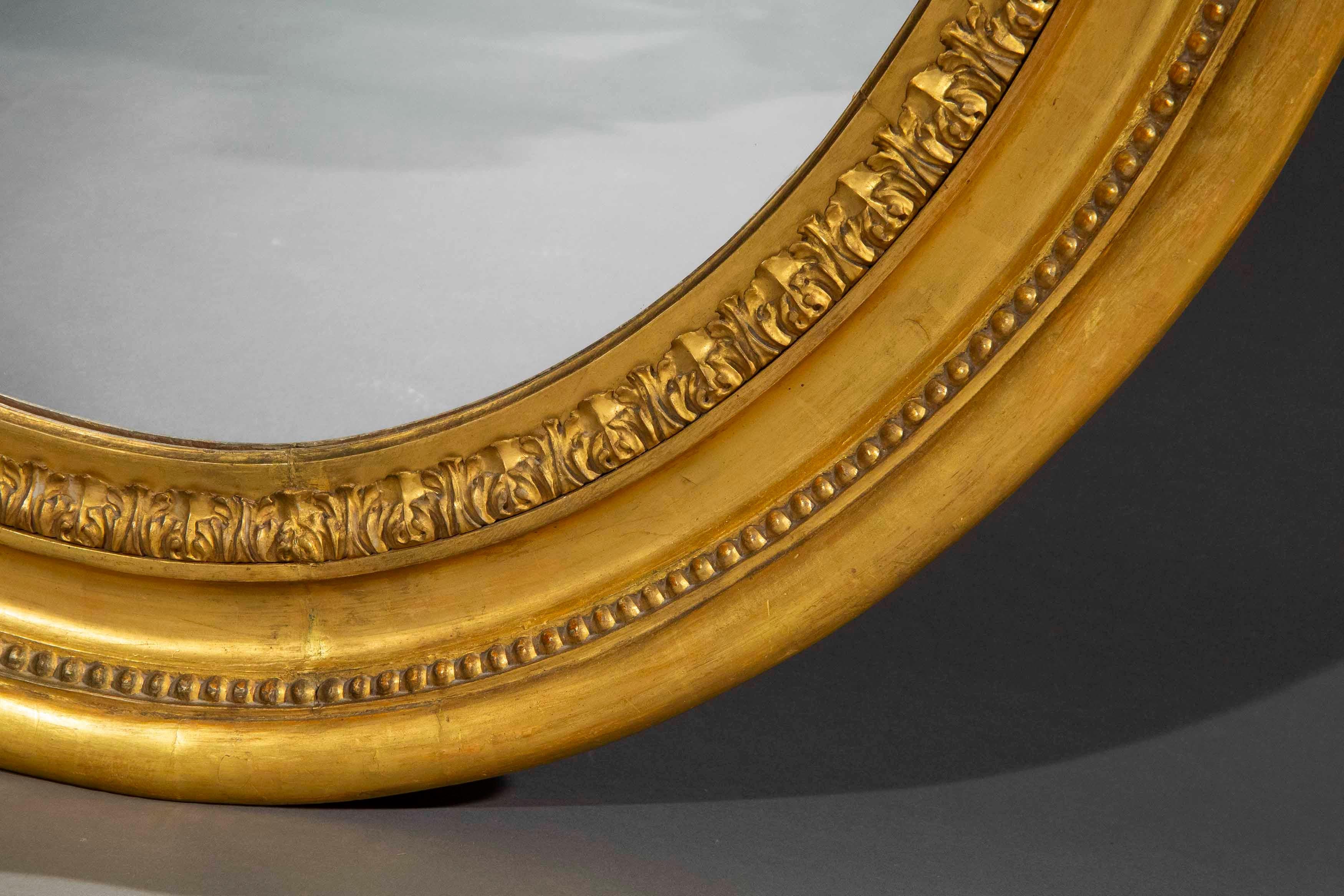 Miroir Grand miroir mural ovale en bois doré du XIXe siècle, C.I.C. en vente