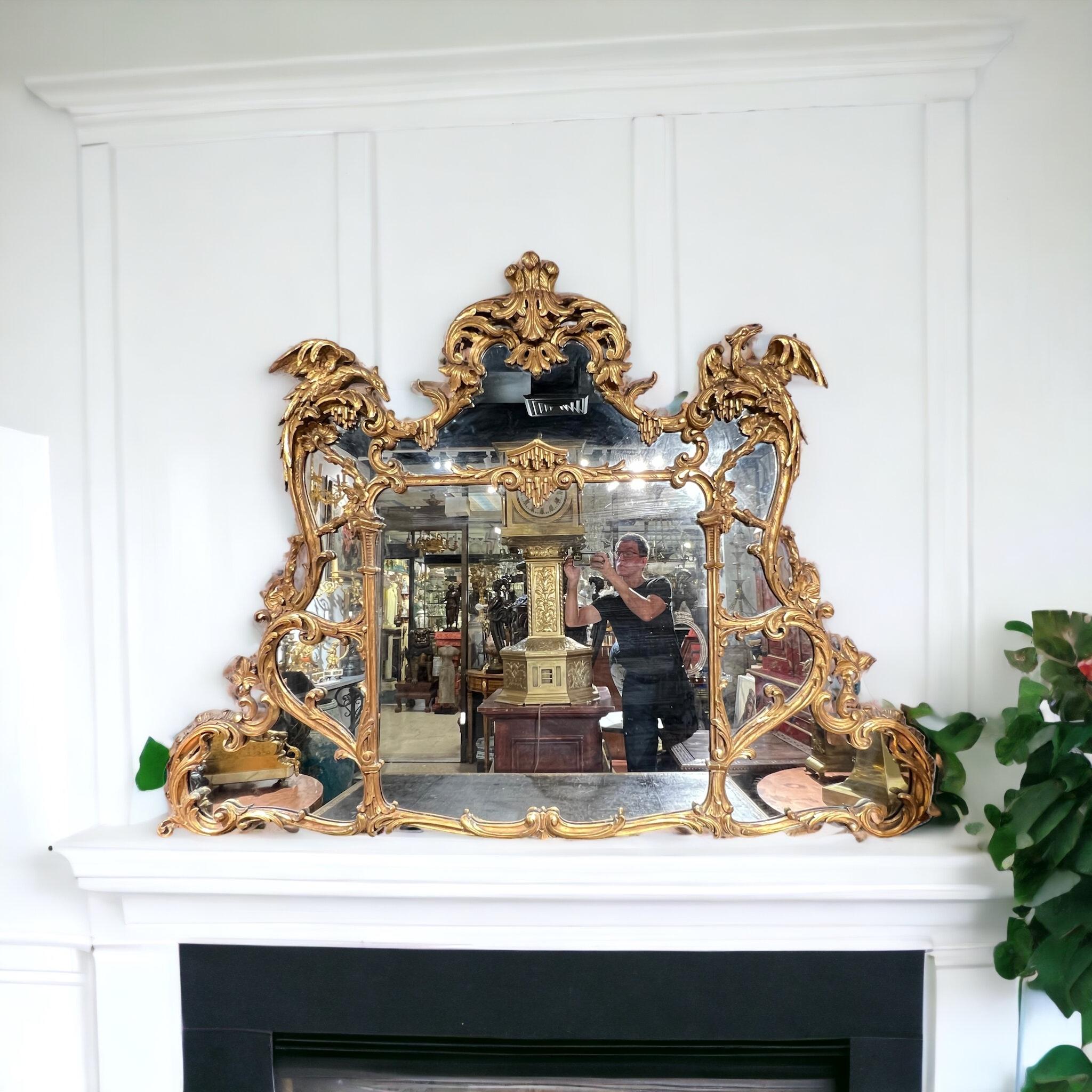 Magnificent antique (19th century) hand-carved giltwood mirror in the Chinoiserie Chippendale style, with ho ho birds, pagoda roof, scrolling s and c-scrolls and feather plume motifs.  Excellent condition.  