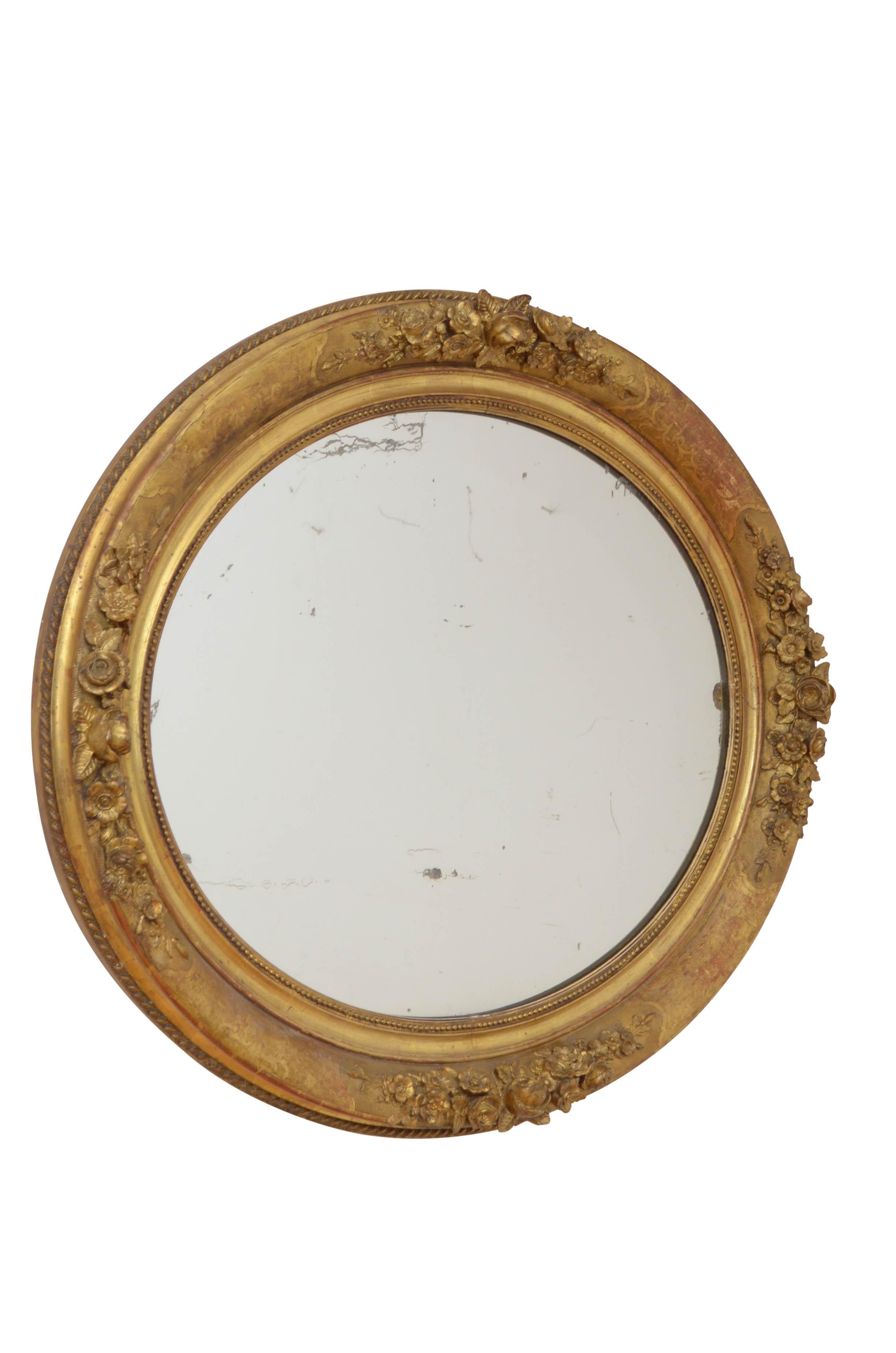 P0184 A superb XIXth century gilded wall mirror of oval design which can be positioned horizontally or vertically, having original foxed glass in beaded and etched frame with floral decoration throughout. This antique mirror retains its original