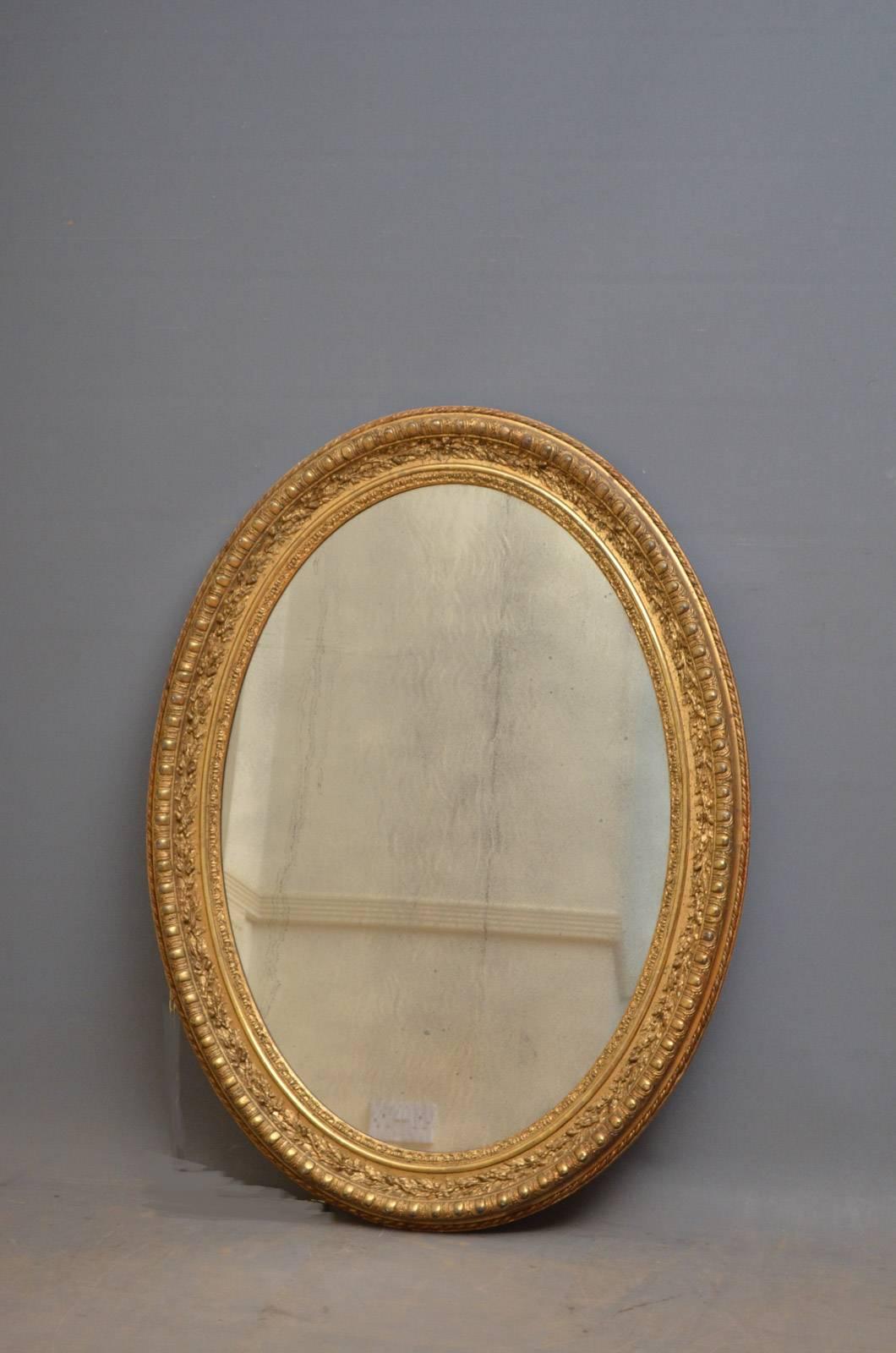 Sn4359, fabulous 19th century wall mirror of oval design, having original, foxed mirror plate in finely carved frame. This antique mirror is in original condition throughout, retaining its original glass, gilt and backboards, all in excellent