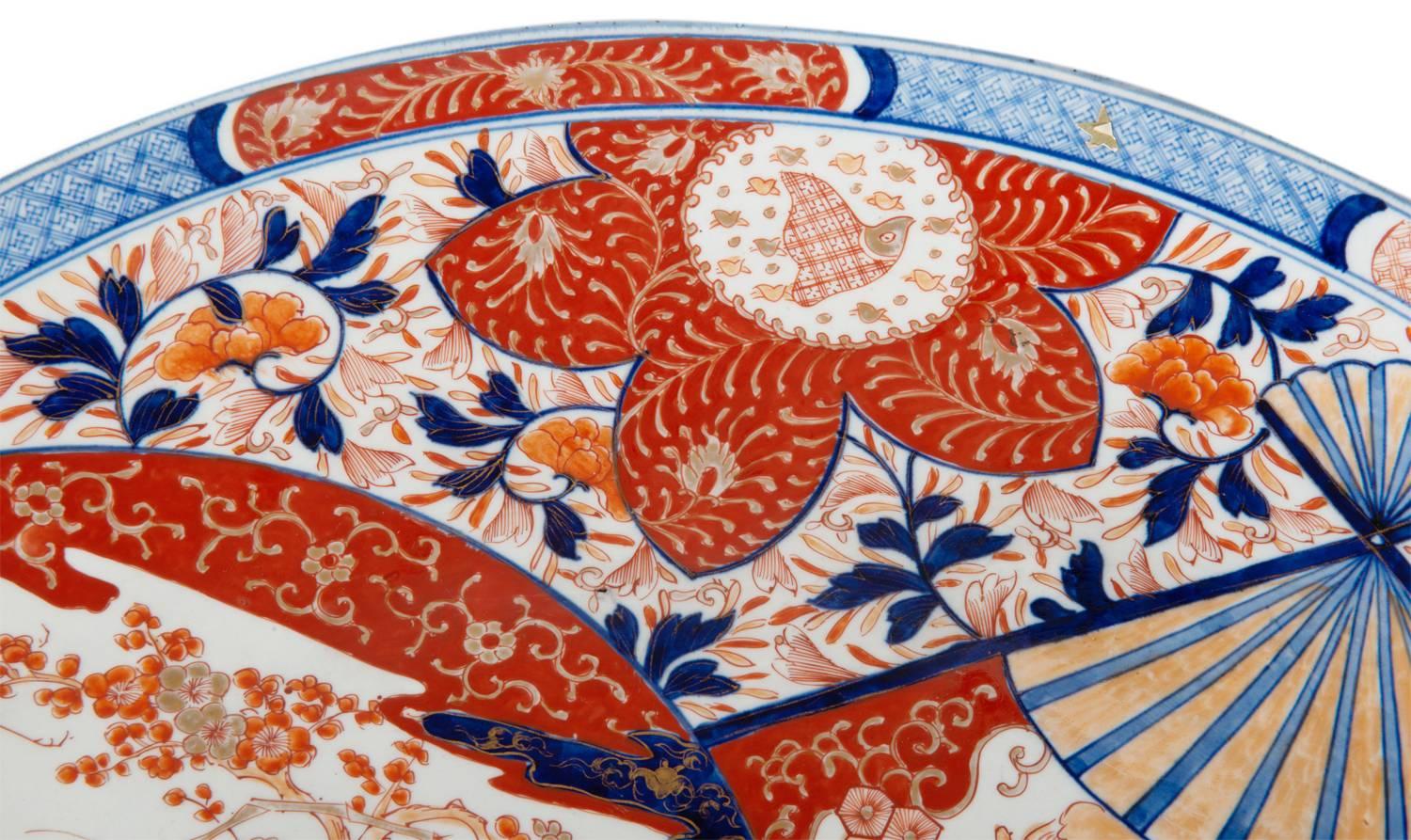 A very good quality mid-19th century Japanese Imari charger, having the classical Imari blue and orange coloring. With floral and motif decoration and inset painted panels in the shape of a fan and mirror.