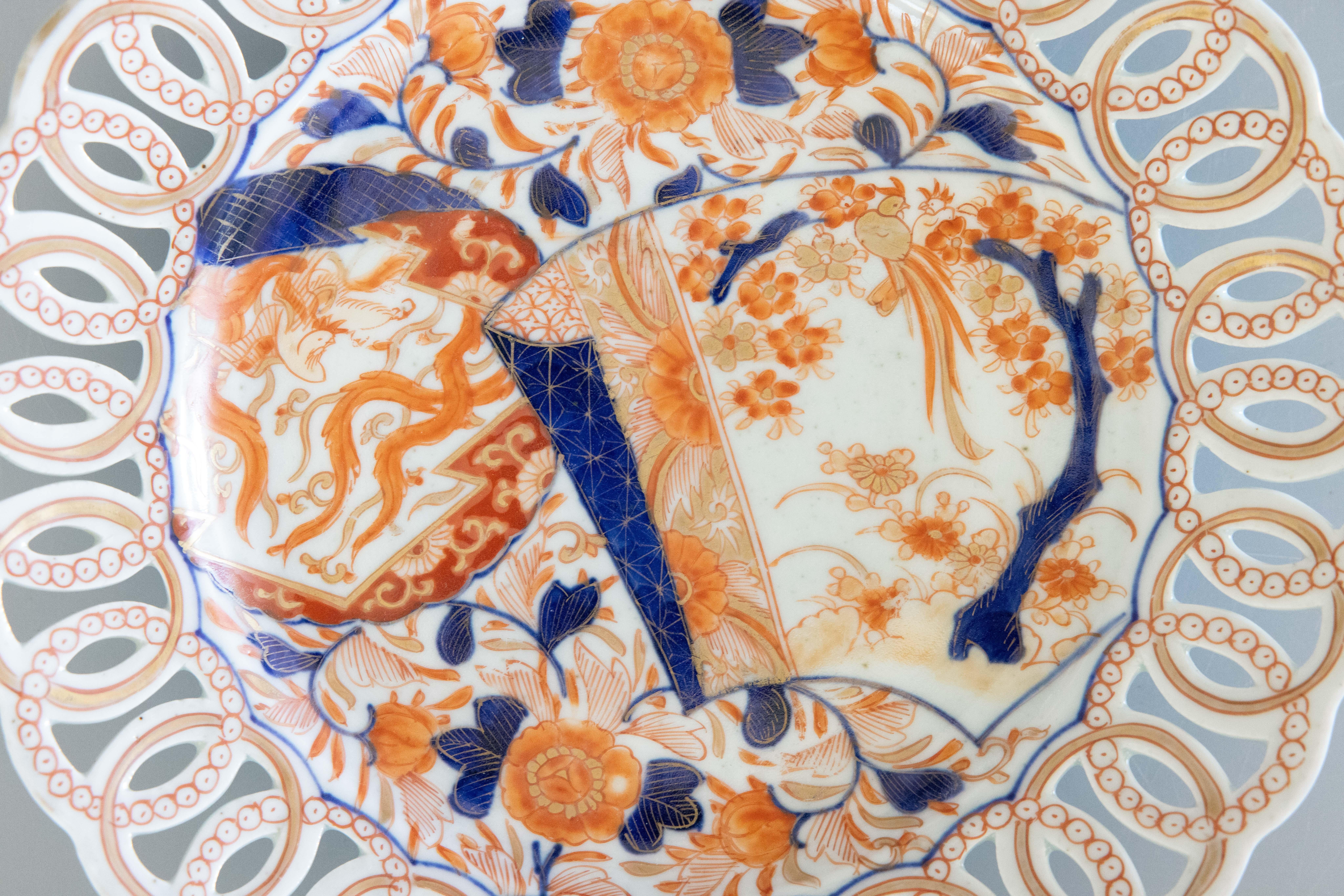 Une grande assiette Imari antique du 19e siècle de 10 pouces avec un bord percé ouvert et un motif floral peint à la main dans les couleurs traditionnelles Imari. Cette belle assiette est ornée d'une jolie bordure réticulée en forme de boucle et se