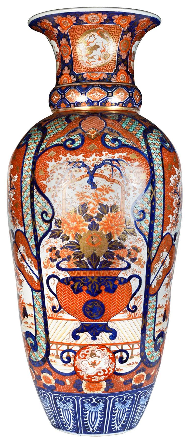 A spectacular late 19th century Japanese Imari vase, having wonderful bold blue and orange ground, classical motif decoration to the boarders, inset hand painted panels depicting exotic birds, flowers, blossom trees and a large vase with