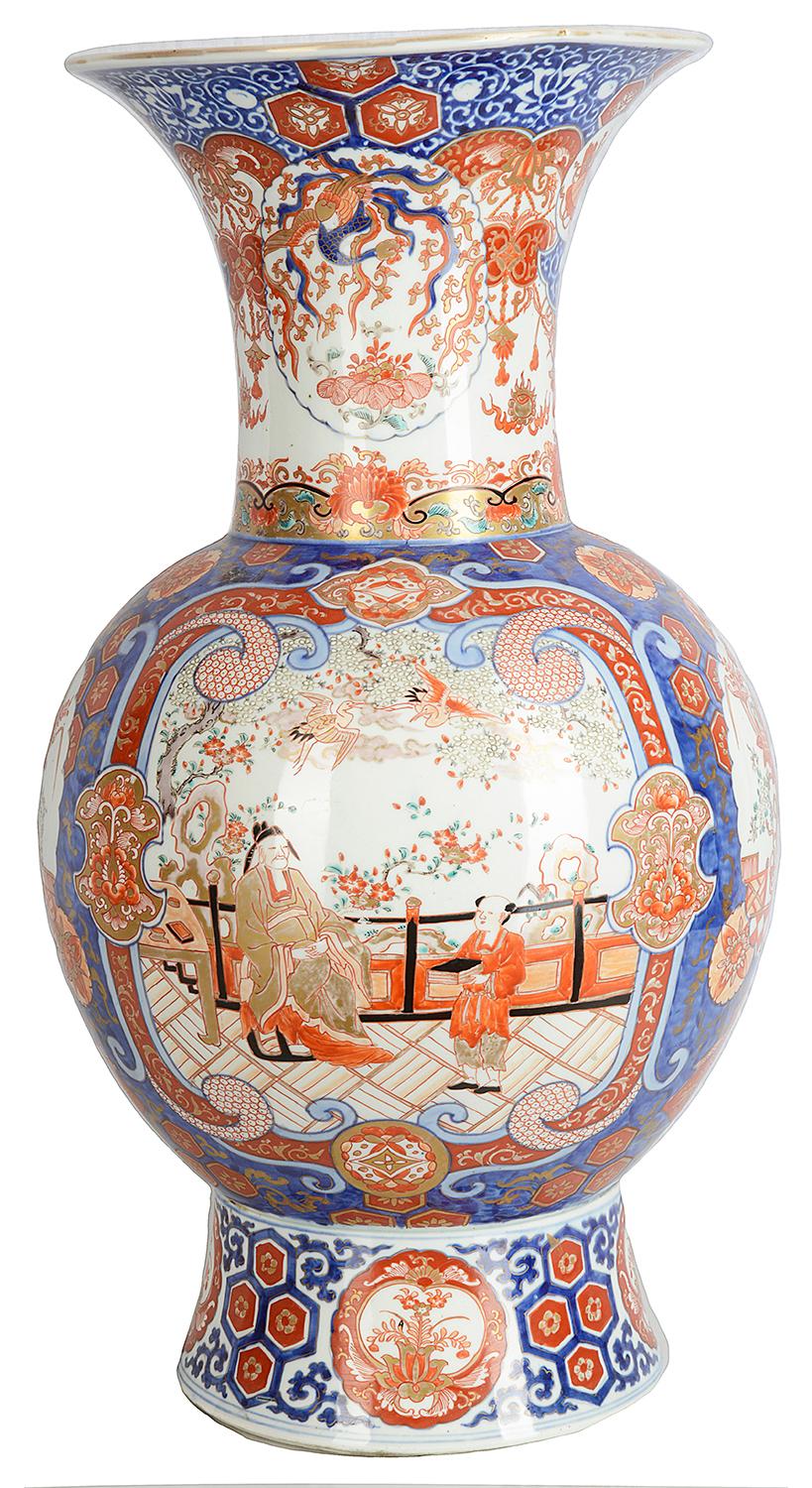 A very good quality late 19th century Japanese Imari vase, having a wonderful flared neck, orange and blue ground, classical motif decoration to the whole, inset panels depicting oriental scenes of people sitting on a veranda in a garden setting