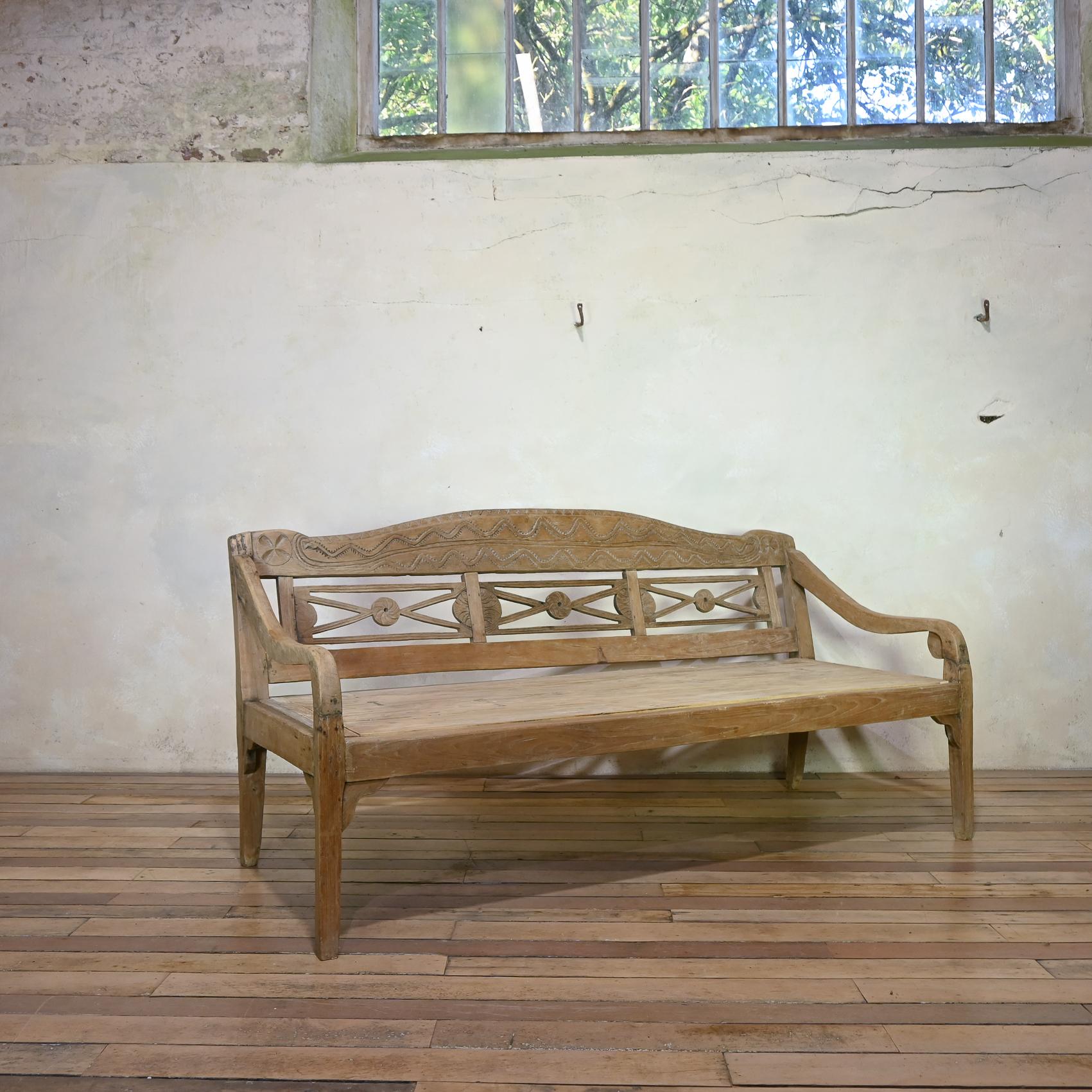 Banc en teck anglo-indien de grande taille datant de la fin du XIXe siècle. Il présente une belle patine d'usage, un dossier sculpté et une assise en planches anormalement profonde. 
Un complément idéal pour l'intérieur ou l'extérieur de votre