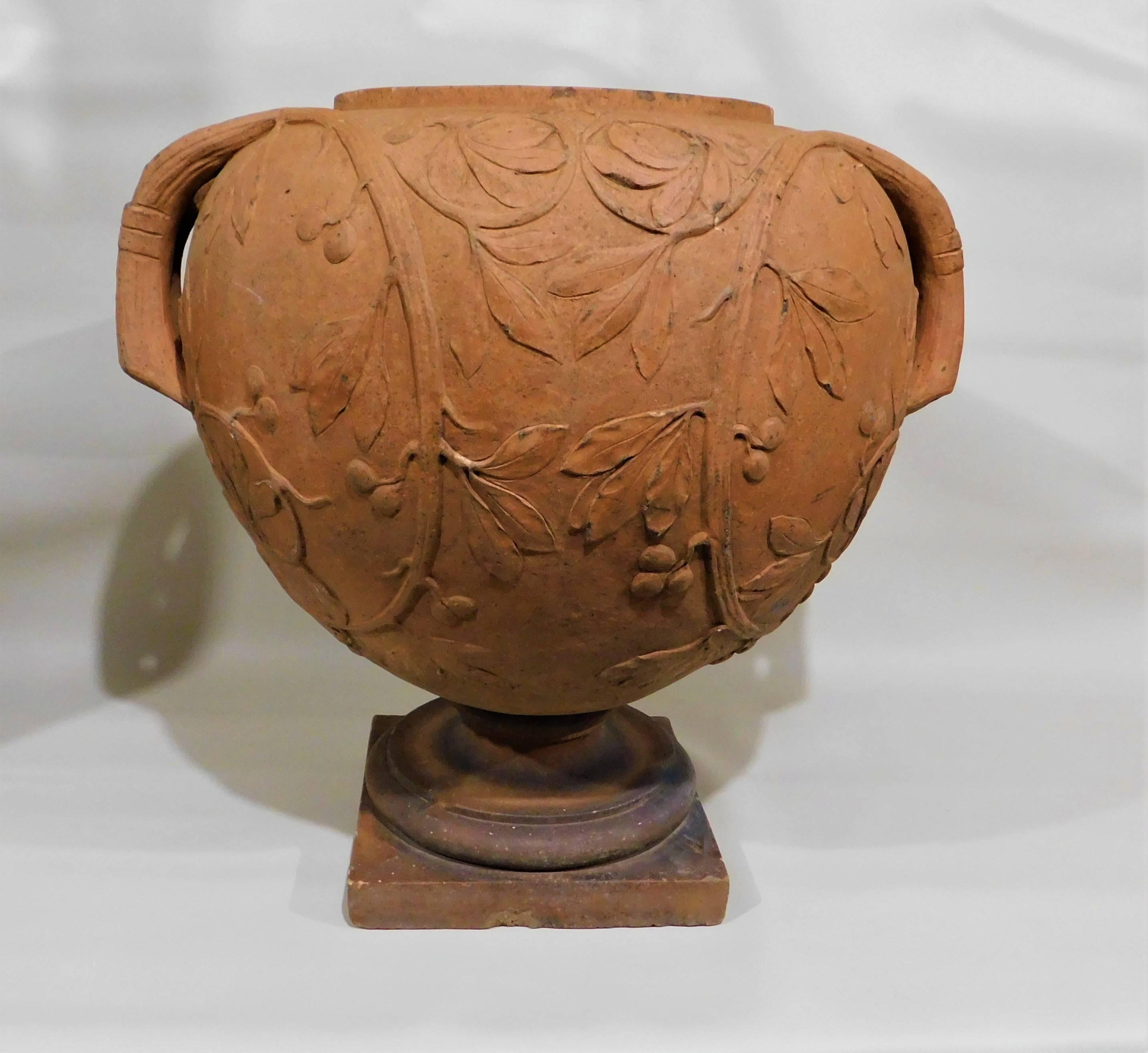 Italian terracotta urn/vase decorated with a grape vine design. Urn comes off the base.