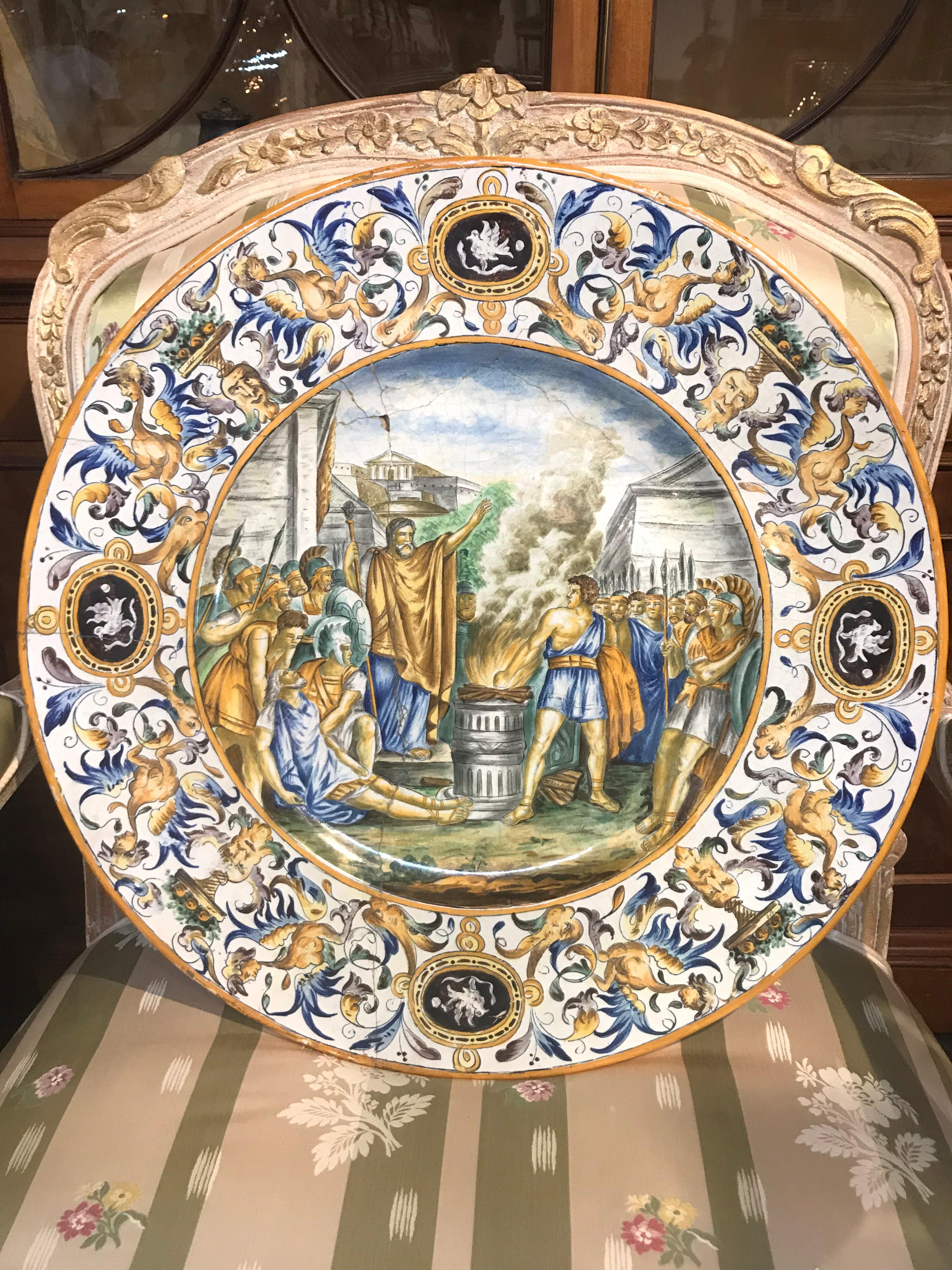 Beautiful 19th century Italian charger with great colors, depicting a conflict between soldiers and a scholar. Very impressive at 24.5 inches in diameter. Please note old repairs throughout, however it is sturdy and still very appealing to the eye.