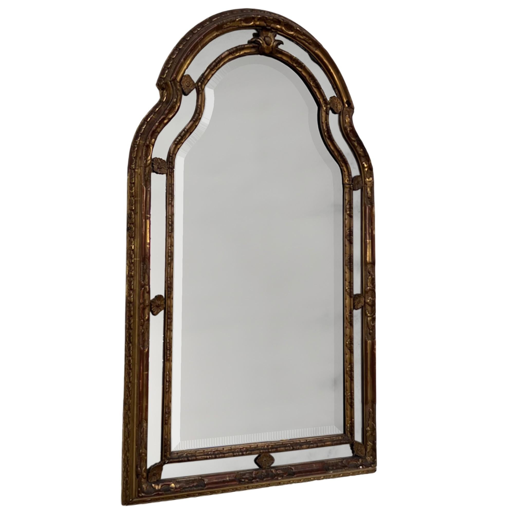 Este espejo decorativo antiguo se fabricó en Italia en el siglo XIX.

El marco de madera dorada conserva su placa biselada original, que está ligeramente oxidada, como corresponde a su antigüedad. 

La parte superior del marco, bellamente arqueada,