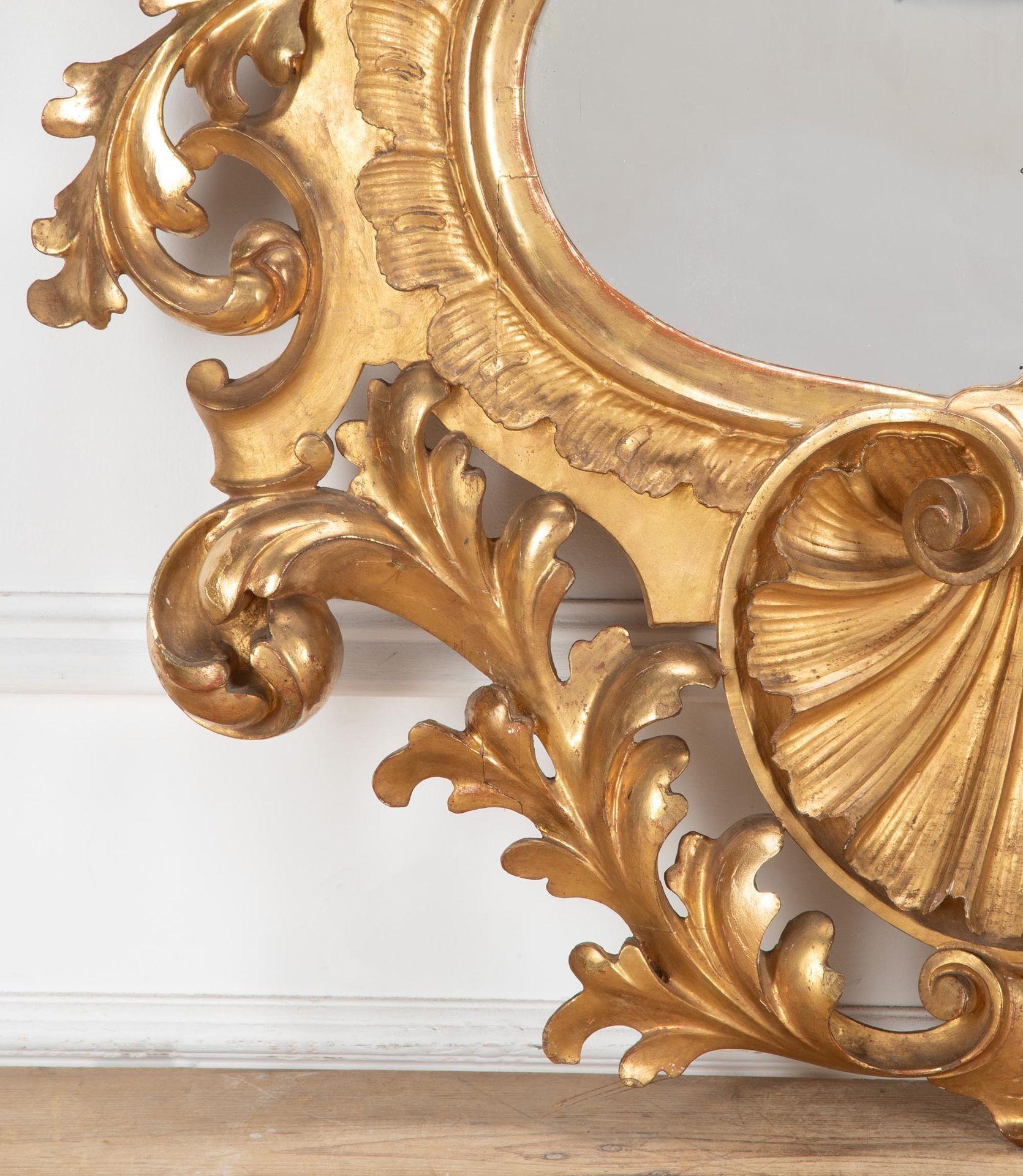 Miroir en bois doré de Florentine du début du 19e siècle, de grande taille et de forme harmonieuse.
Dans le style du XVIIIe siècle, avec un cimier à plumets, flanqué d'ailes et de rinceaux élaborés, se terminant par une coquille Saint-Jacques.
En