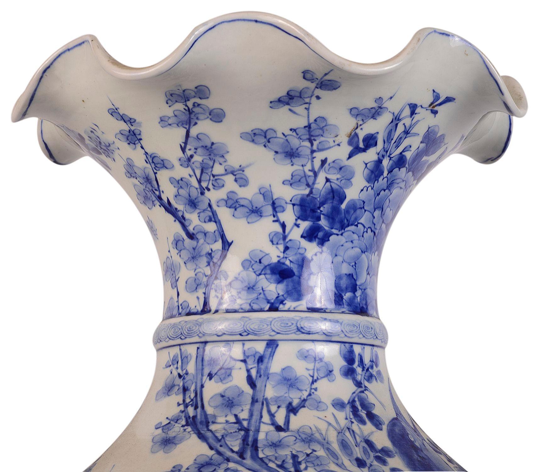 Très impressionnant vase japonais bleu et blanc de bonne qualité de la fin du XIXe siècle, avec un col évasé, une magnifique décoration florale peinte à la main en bleu, le dragon en relief s'enroulant autour du vase, la base décorée d'une bordure à