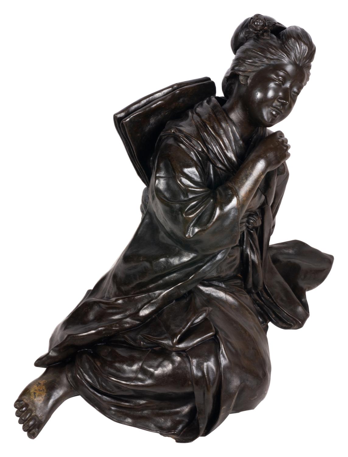 A wonderfully impressive late 19th century Meiji period (1868-1912) Japanese patinated bronze study of a reclining geisha girl.

Signed to the reverse.