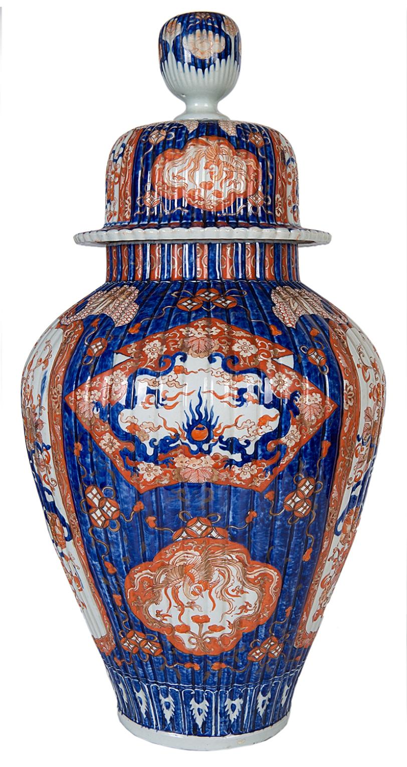 A very good quality 19th century Japanese lidded Imari vase, having fluted form to lid and vase, with classical motifs, flowers, foliage, ribbons and balls. The main panels with mythical dogs of Faux playing with balls, exotic birds amongst flowers