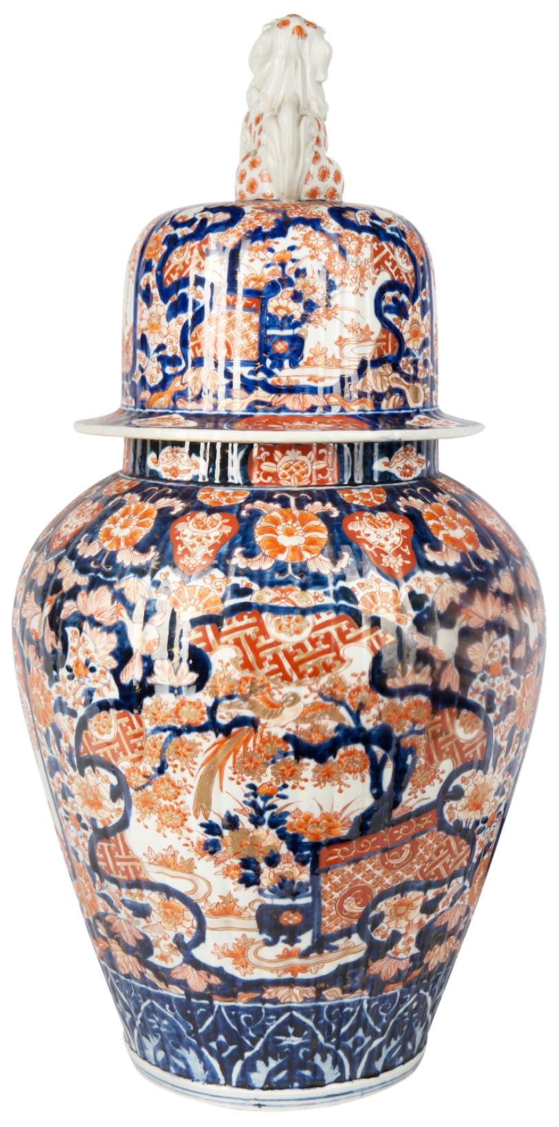 An impressive 19th century Japanese Imari lidded vase, depicting classical floral scenes set in panels and a shishi dog mounted on the lid.