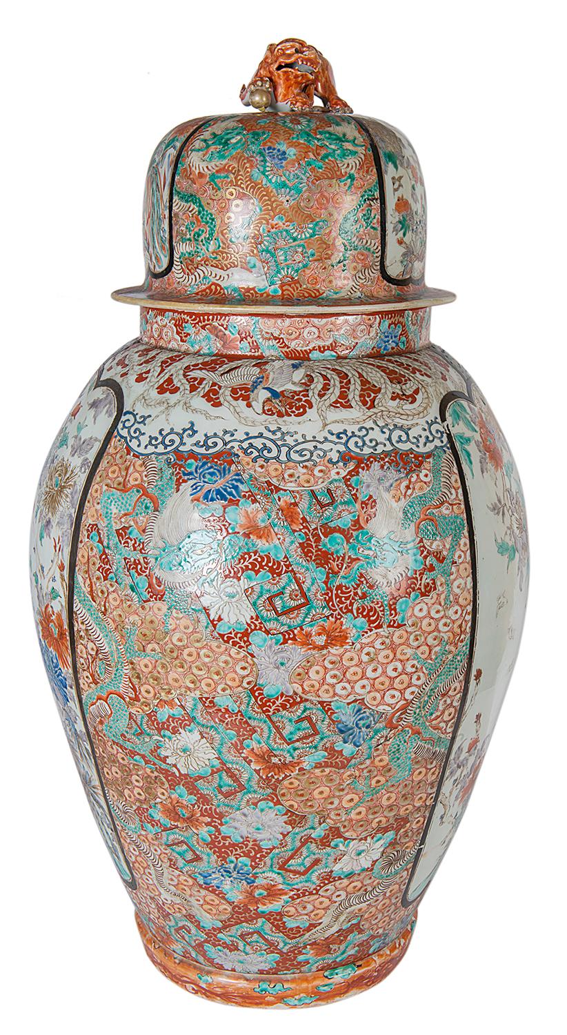 A large and impressive 19th century Japanese Kutani lidded vase, having a dog of faux finial to the lid, inset painted panels depicting exotic birds, flowers and foliage. The ground in classical Imari / Kutani colors, geometric motifs and mythical