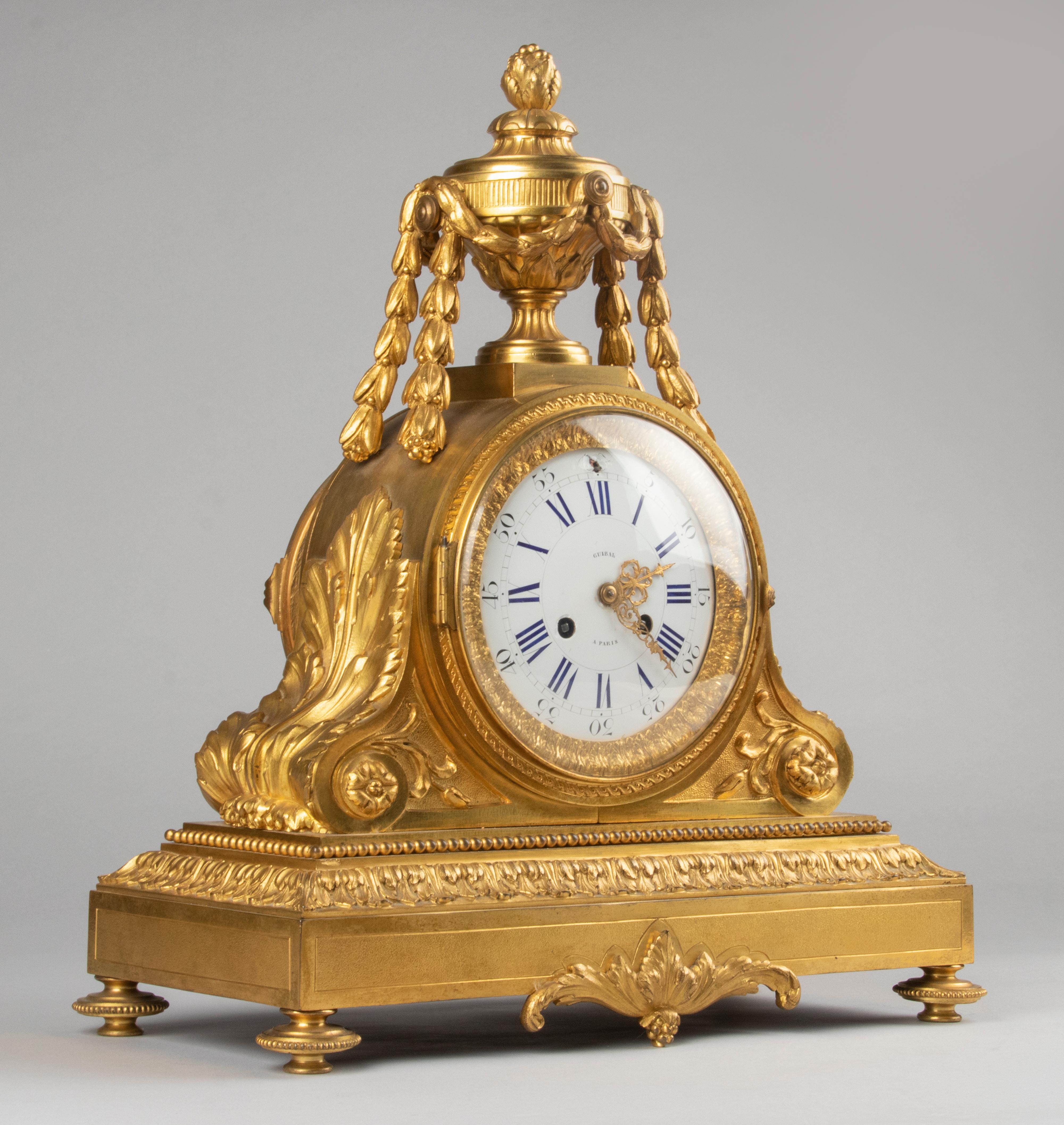 A fine and large Louis XVI style French mantel clock, from the end of the Napoleon III period, 1870-1880. The clock is bronze casted and has a fire-gilded finish, the dial is enameled copper. Richly all around embellished with neoclassical ornaments