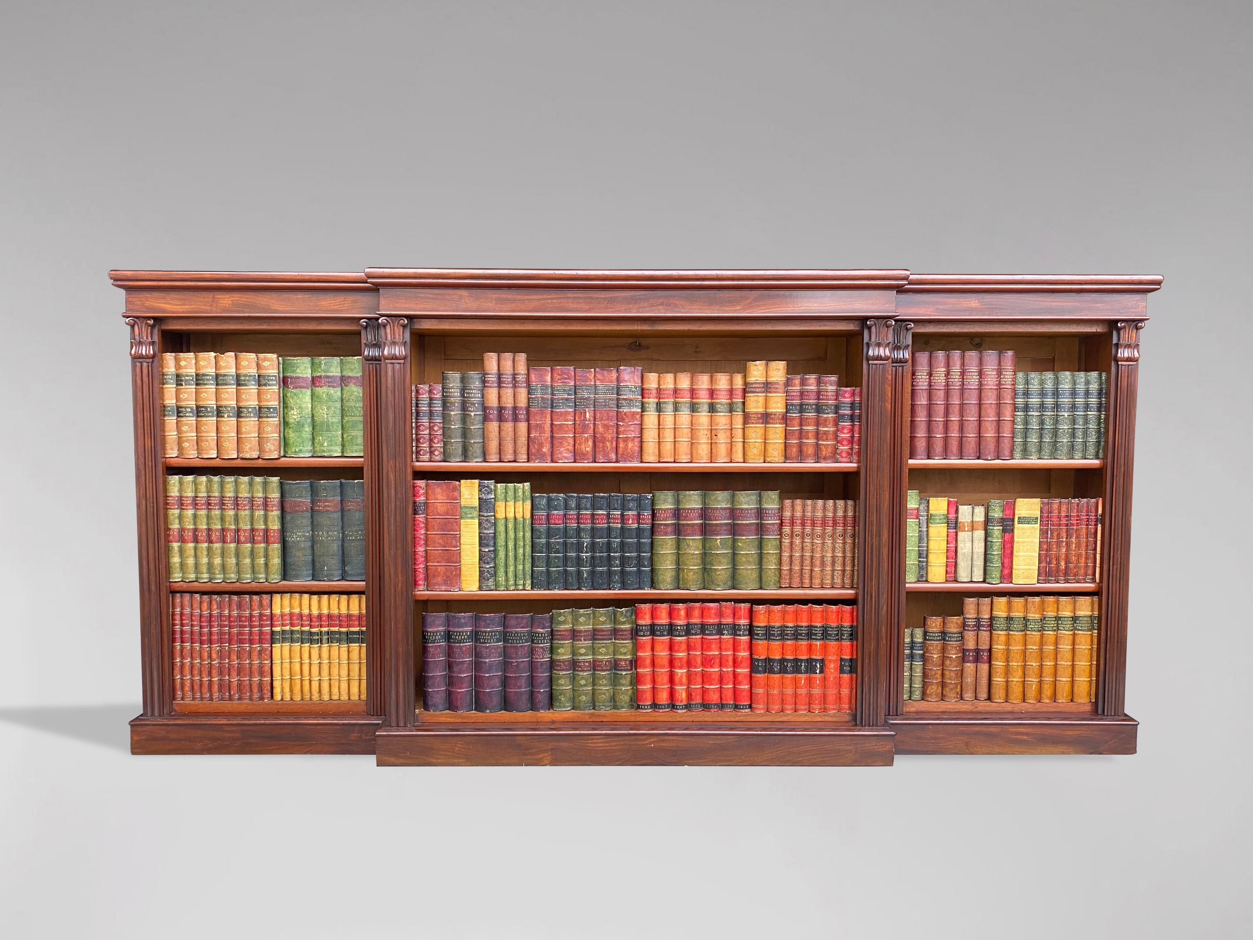 Large 19th century, early Victorian period solid mahogany breakfront open library bookcase. Each section has two adjustable shelves, providing substantial display space for books, flanked by six carved reeded pillars or columns with capitals. All