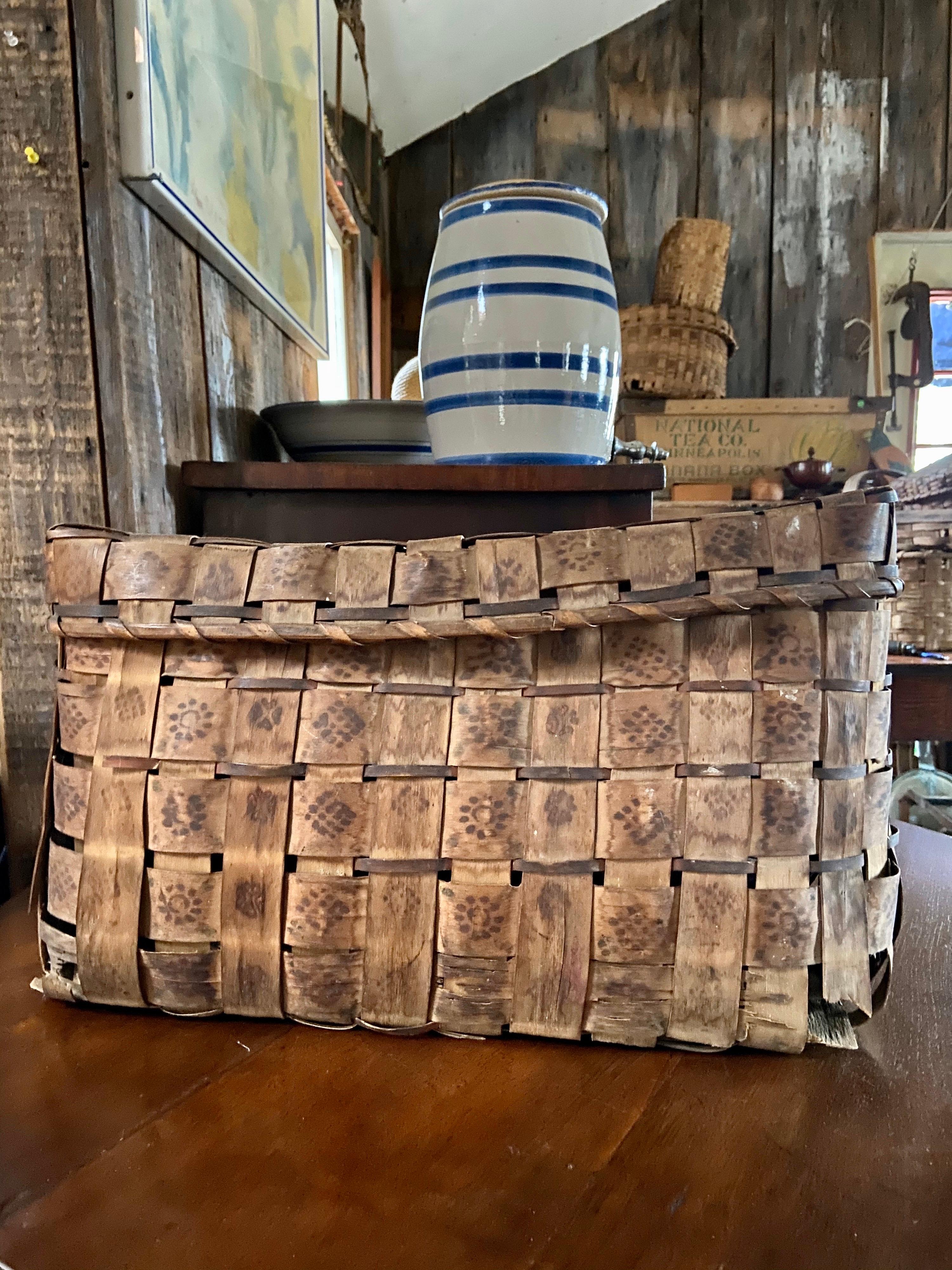 This large lidded Native American Mi’kmaq basket is from northern Maine. Traditional use is for feather storage. Handwoven by indigenous artisan. Subtly decorated with natural dyes. Bottom corners damaged, but structurally sound.

Measures: 19”