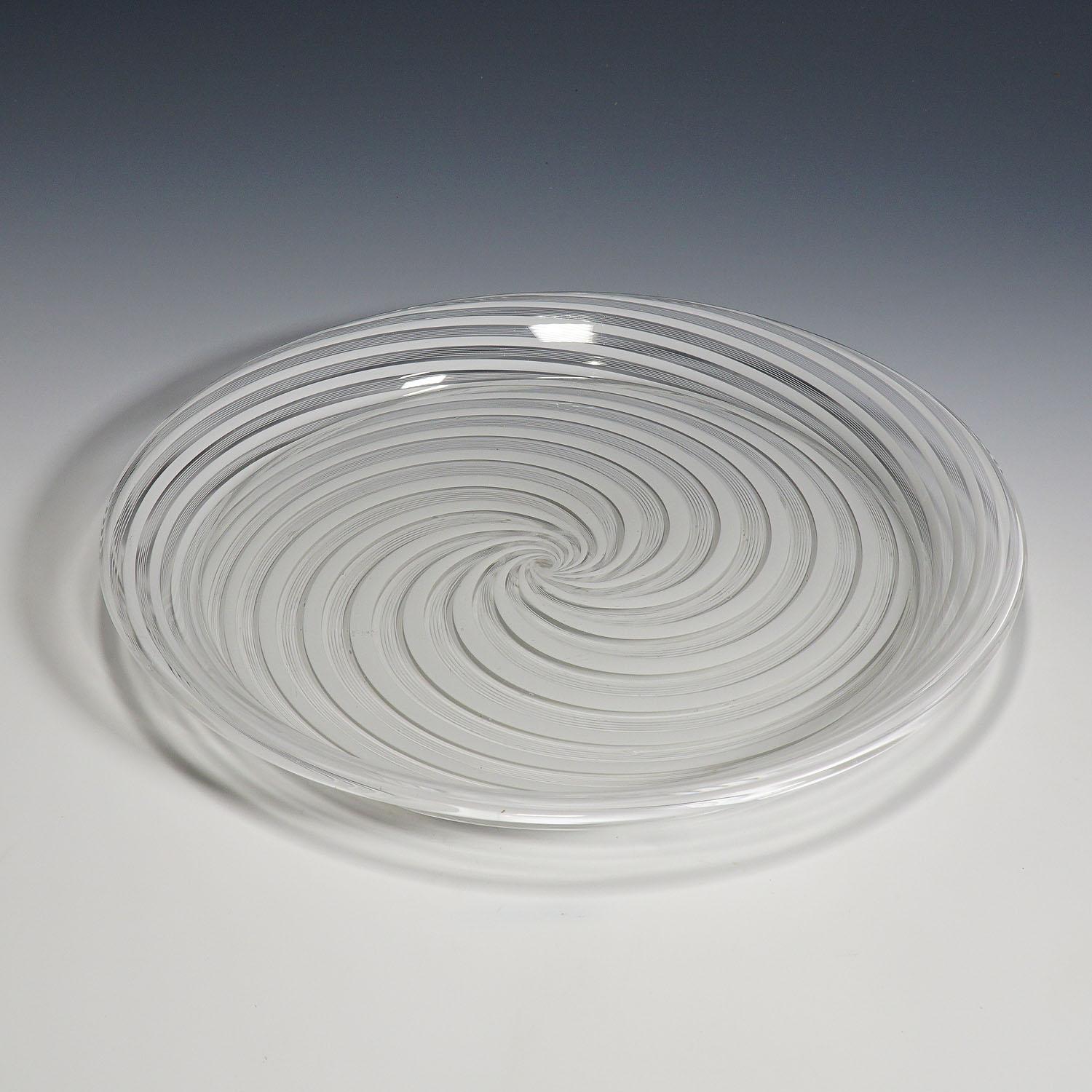 A large art glass plate made of clear glass with white filigrana bands. Attributed to Societa Anonima for Azioni Salviati & C., Murano second half of the 19th century.

Measures: height: 1.18