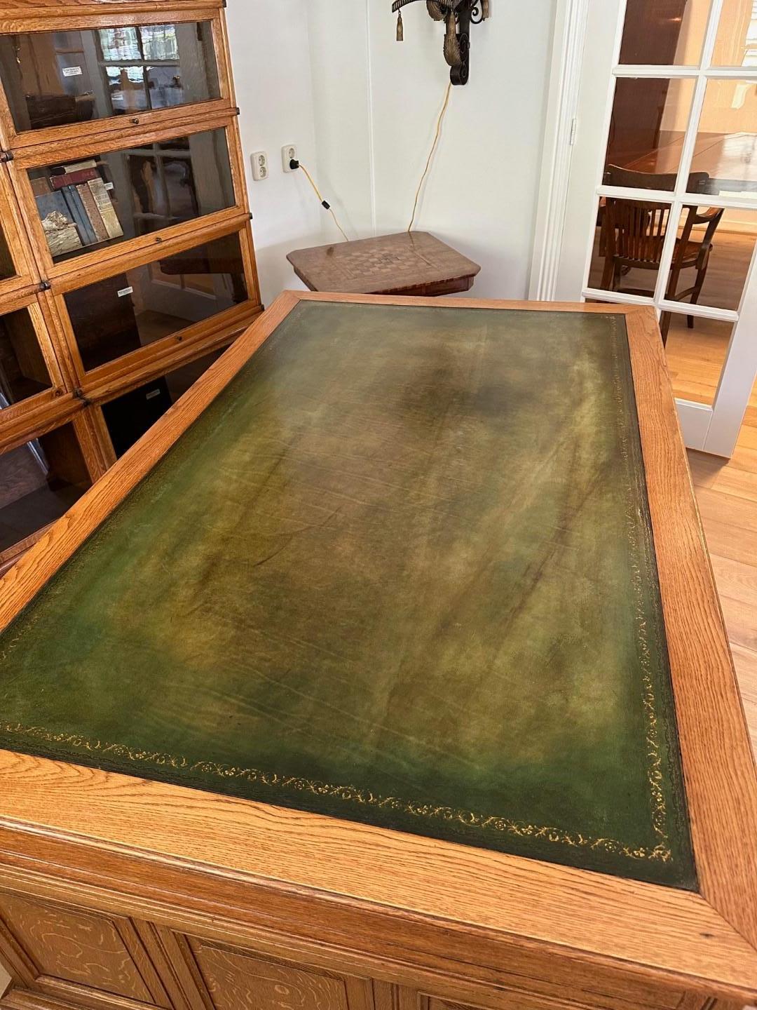 Impressive 18 drawer oak partners desk,  9 drawers on both sides. In beautiful light oak color with aged green leather top.
Desk is completely in original condition with beautiful handles on the drawers. Nice practical desk to work on alone or with