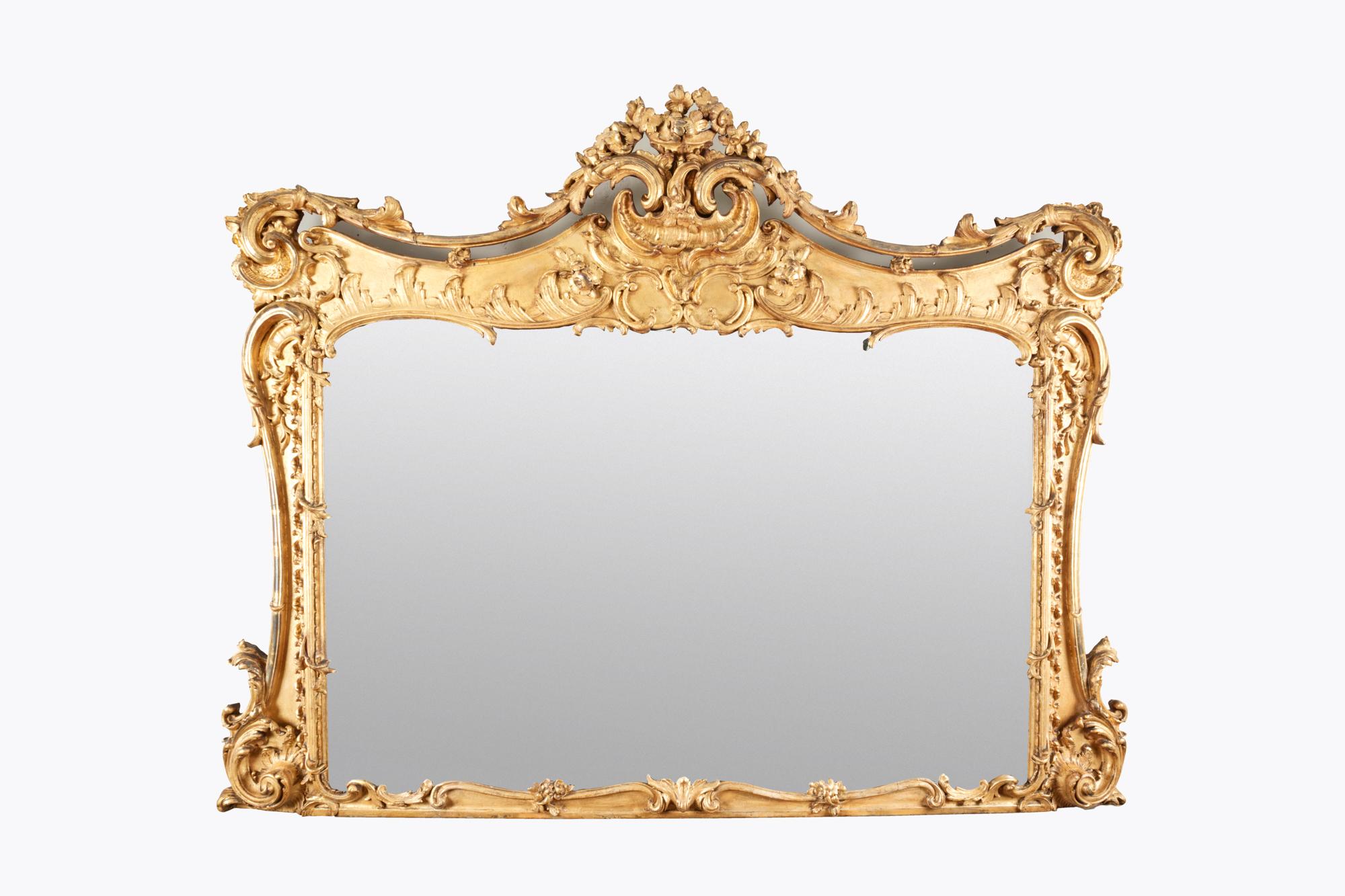 Large 19th century ornate gilt Chippendale-style overmantle mirror. The frame is decorated with foliage, acanthus swags and gadrooned scrolled corners. The detailing of the carving extends to the sides and edges.
