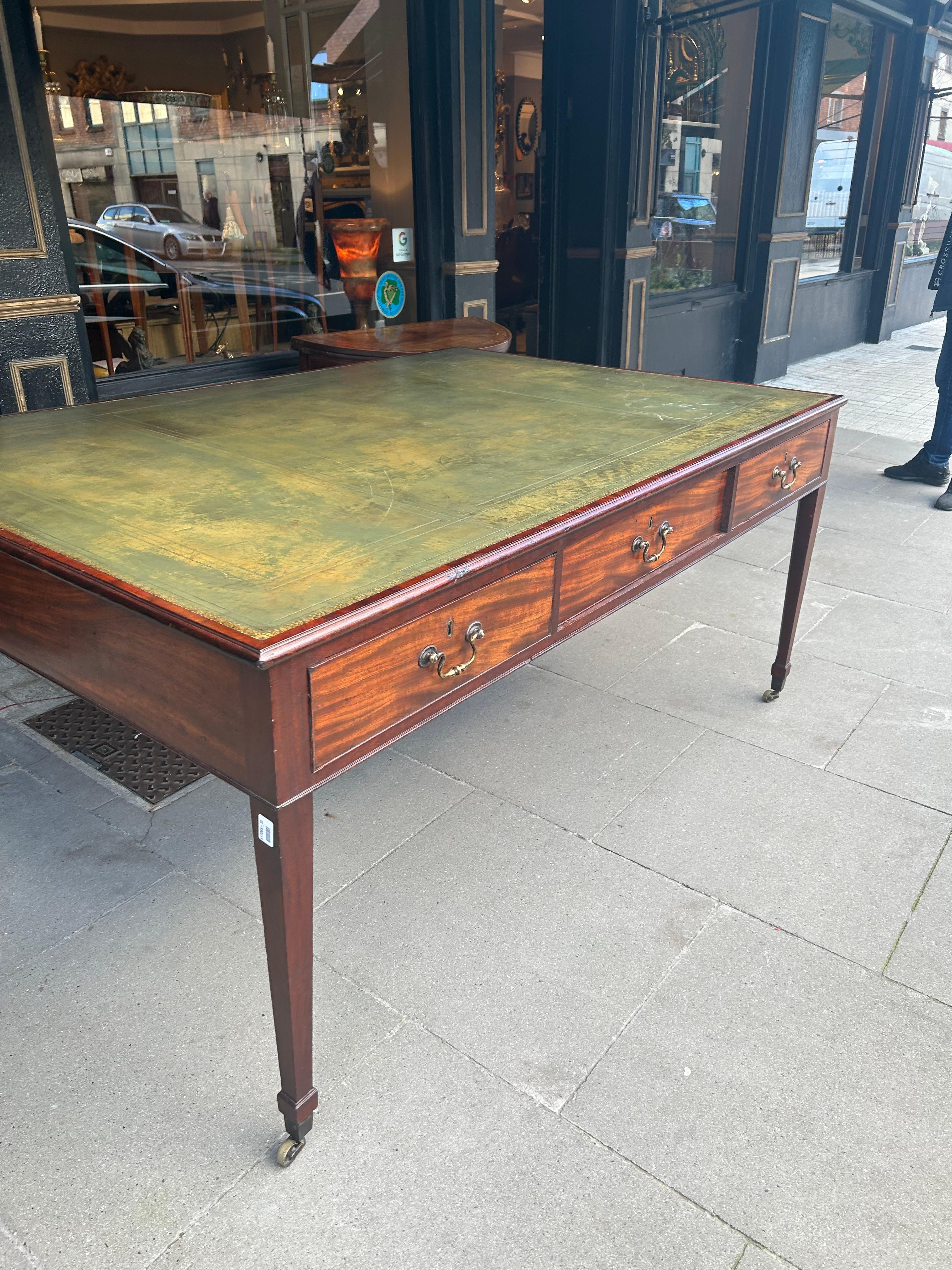 Large 19th Century partners library table with tooled Green Leather top. The moulded rectangular top sits above three cross banded drawers complete with brass swan neck handles. Raised on four square tapering moulded legs, it terminates on simple