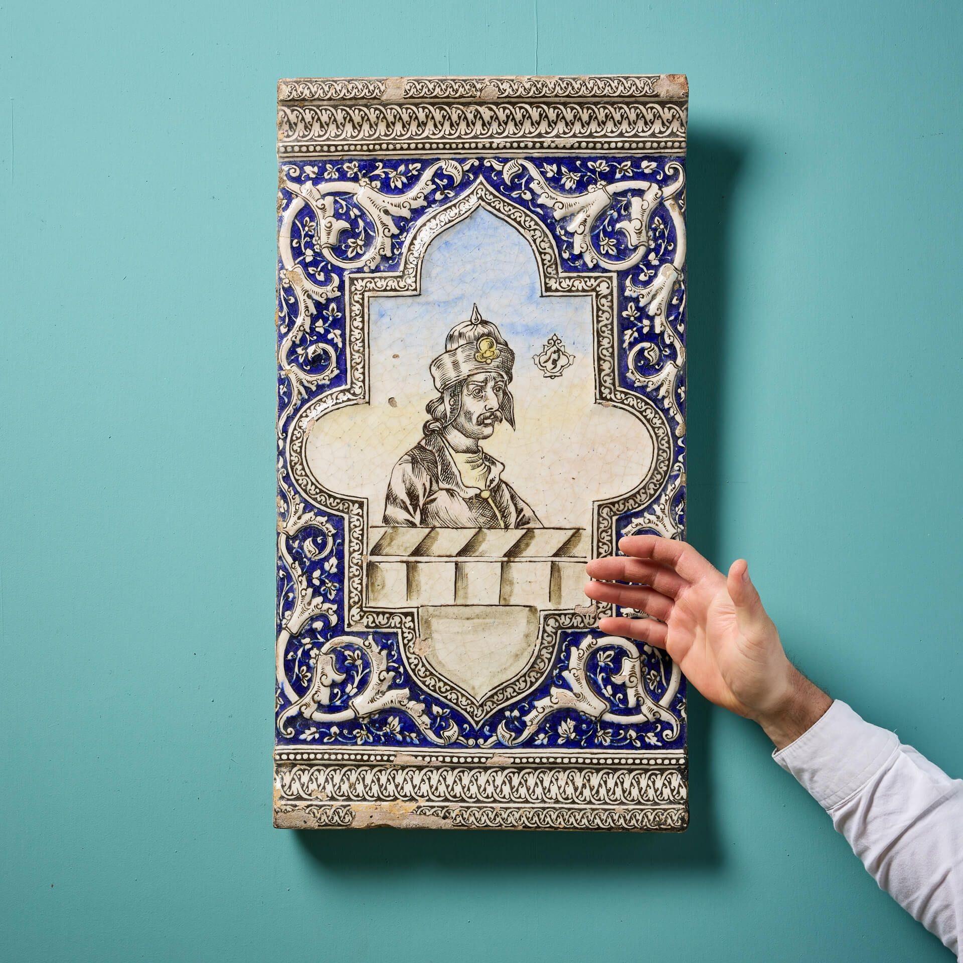 Eine seltene große islamische Fliese aus persischer Qajar-Keramik aus dem 19. 

In großem Maßstab gemalt mit der Darstellung eines persischen Prinzen in einer geformten Kartusche, flankiert von Blattwerk und Ranken.

Ein ausgezeichnetes dekoratives