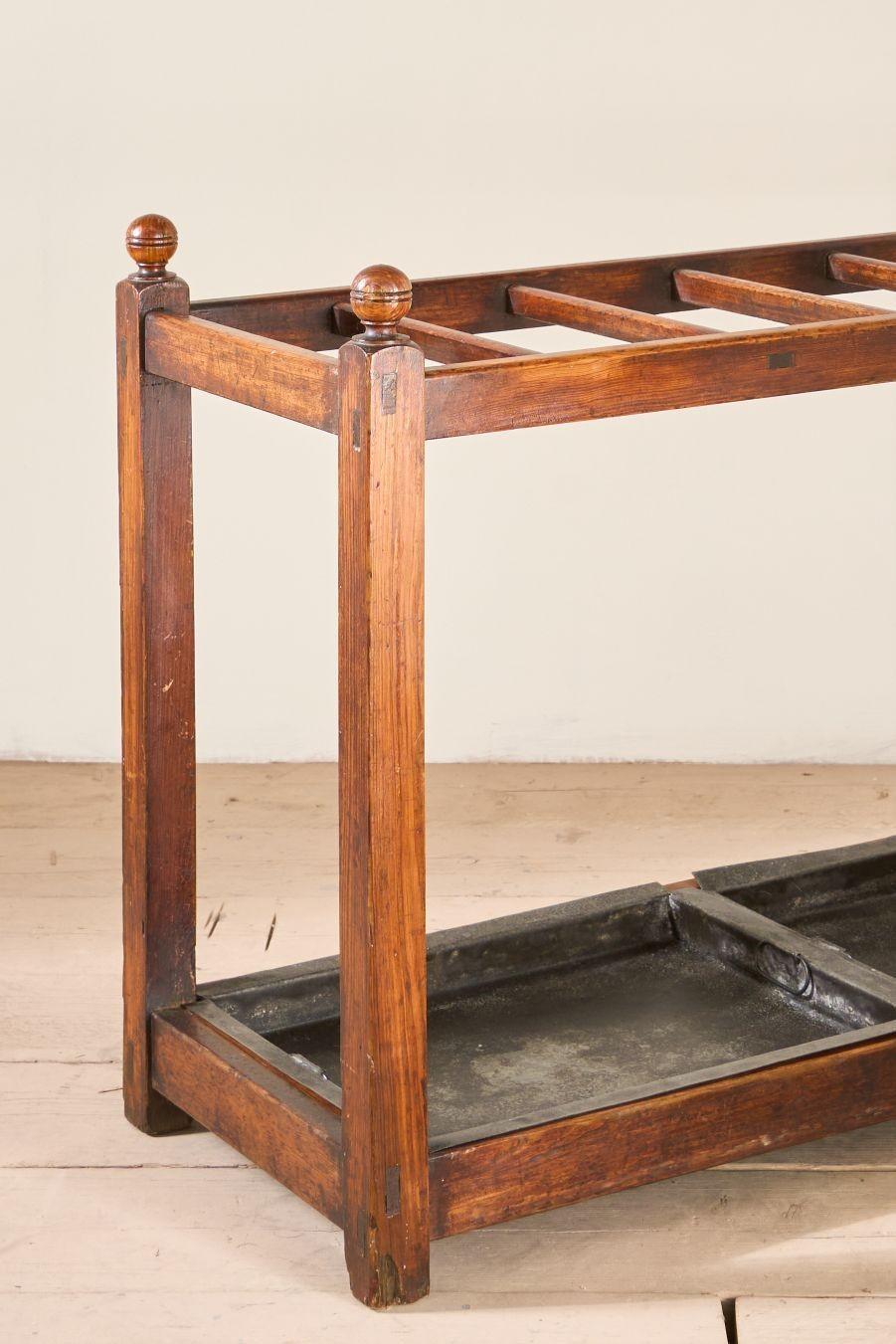 This is a great looking 19th century stately home pitch pine stick and umbrella stand. Very well made and the overall condition is superb with the original metal drip trays. The patina from years of use give this a very handsome look that would sit
