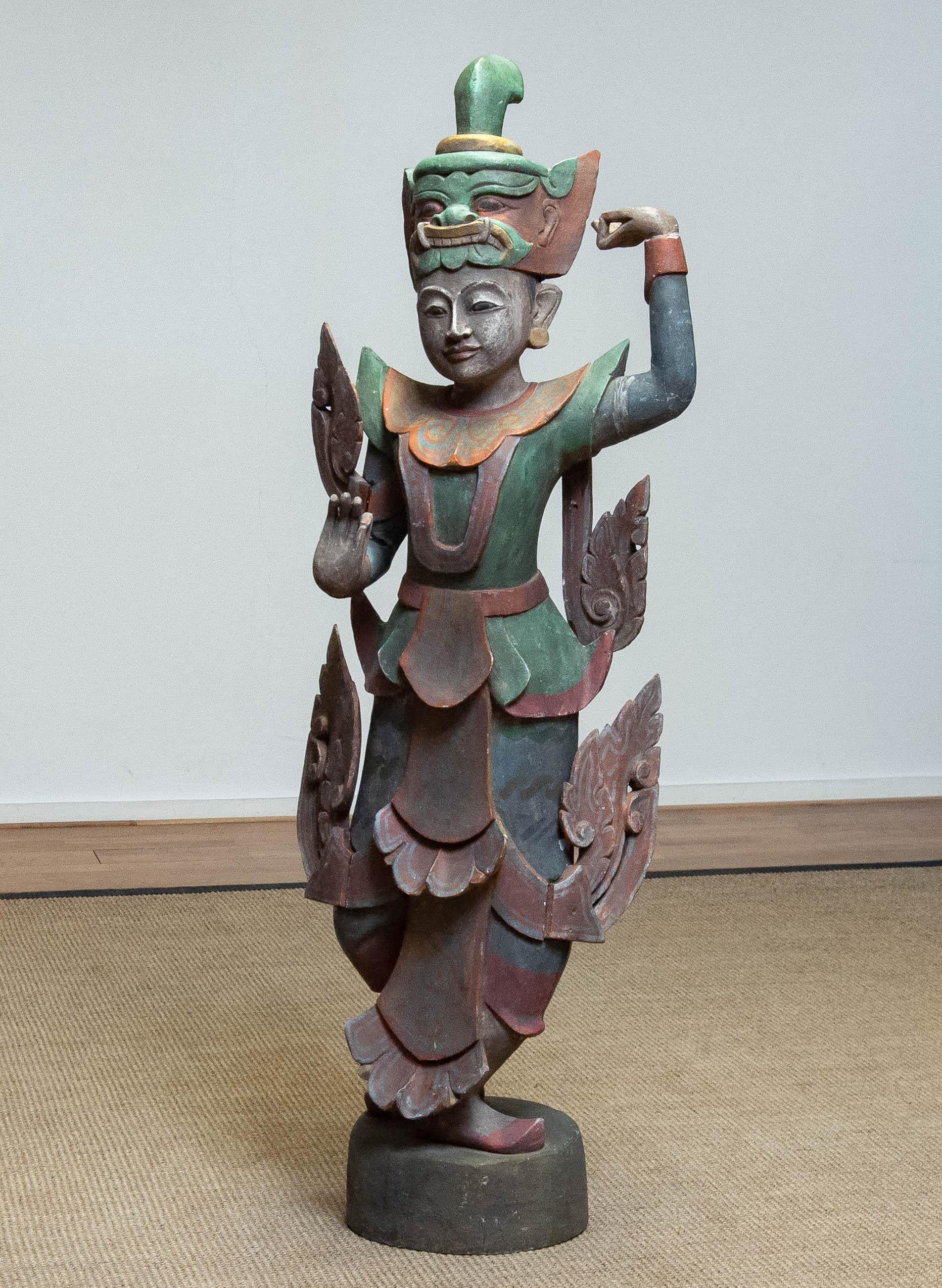 Absolument magnifique grande danseuse de temple birmane polychrome du 19ème siècle sculptée à la main dans un morceau de teck. 
Pièce d'art très décorative. Hauteur 127 cm / 50 Inches.
Veuillez noter que nous avons une deuxième danseuse en