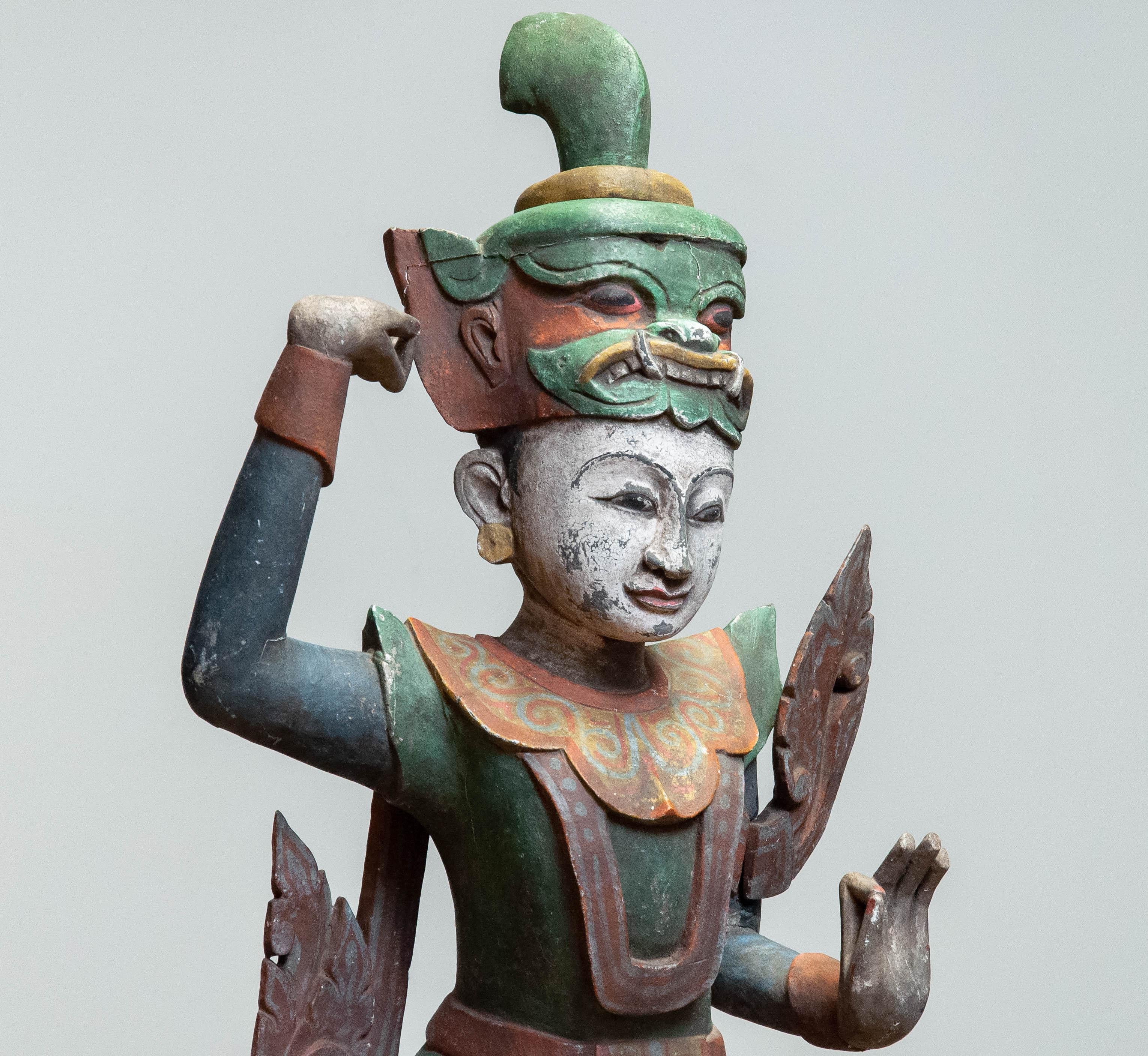 Hand-carved wooden sculpture representing a traditional guardian or deity figure, often referred to as the 