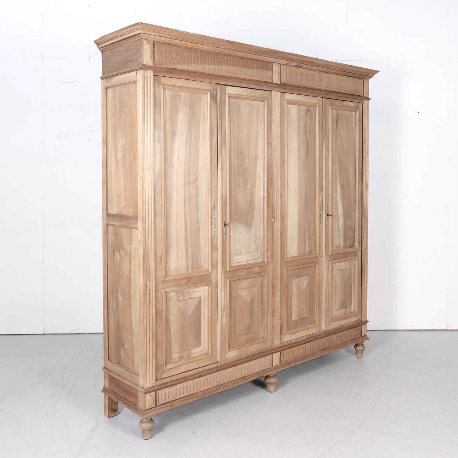 Large 19th century French Henri II or Renaissance Revival period four-door placard or armoire handcrafted in Provence of solid walnut that's been bleached or washed to a natural finish, circa 1880s. This beautiful bleached placard features a