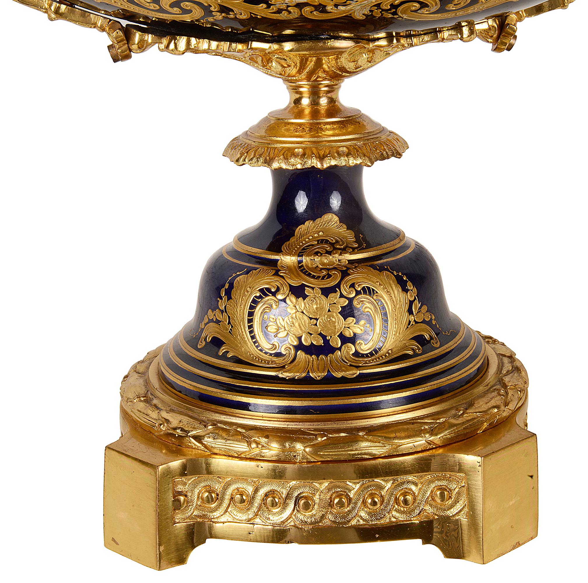 A very impressive, good quality late 19th century French Sevres style porcelain comport. Having wonderful twin gilded ormolu monopodia handles, a pierced scrolling foliate gallery. Cobalt blue ground with gilded classical decoration surrounding an