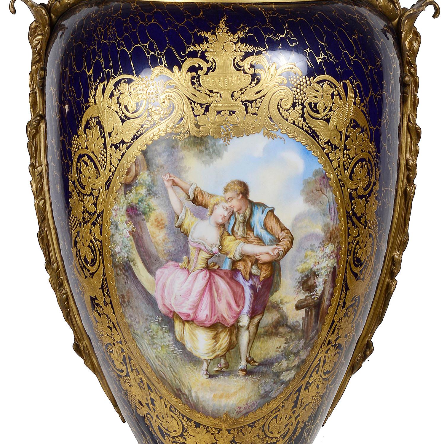 A wonderful quality late 19th century French 'Sevres' style hand painted porcelain lidded vase. Having a cobalt blue ground, classical scrolling gilded decoration, gilded ormolu mounts and handles, inset painted panel depicting a romantic scene of