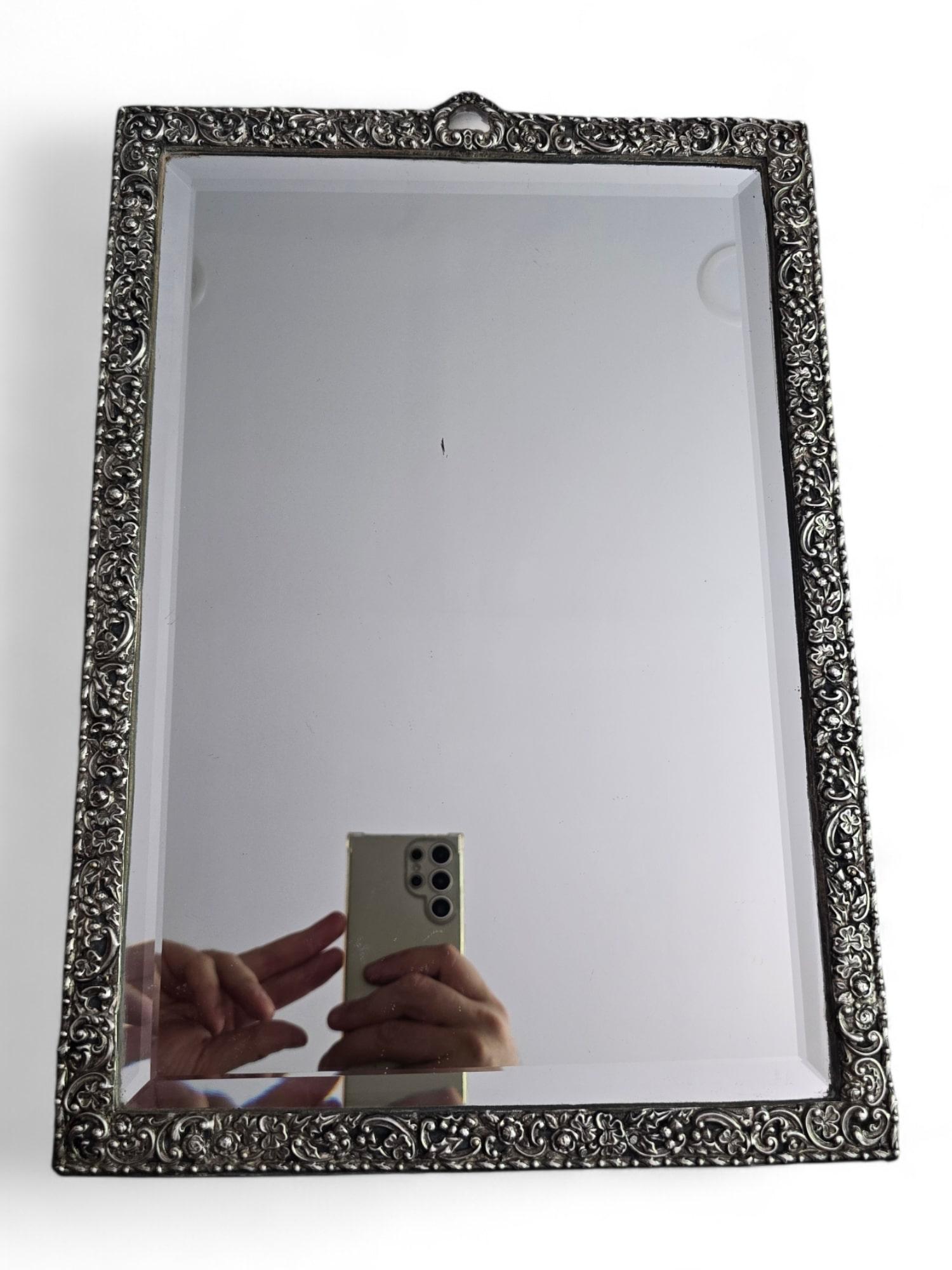 Presenting an elegant and large 19th-century mirror with an intricately carved silver frame. This exquisite piece showcases the artistry of French craftsmanship, with detailed silverwork that reflects the refined aesthetics of the period. The mirror