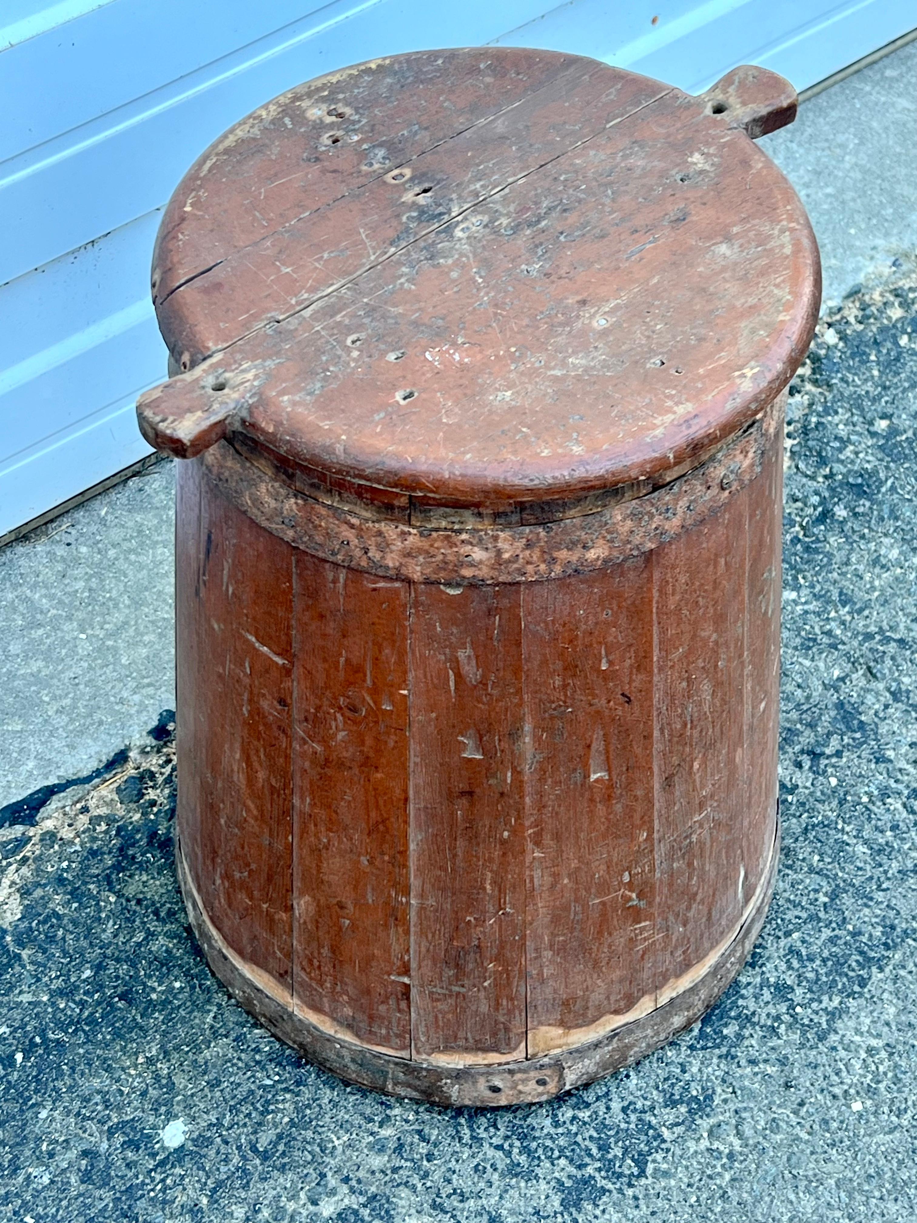 Lidded 19th century wooden bucket with slat and wrought iron banding construction.  Top removable, in all-over original reddish-brown paint.  Great little side table.
