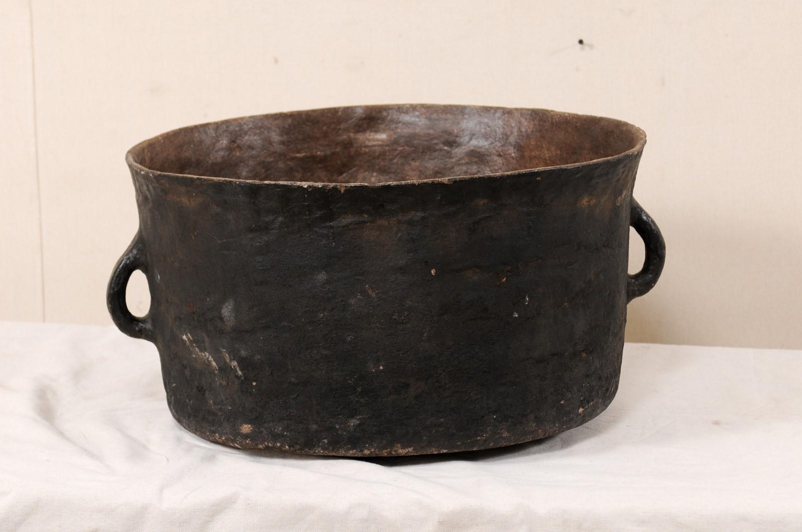 A Spanish Colonial cooking pot from the mid-19th century, Central America. This Spanish Colonial cooking vessel made of clay, is flanked with two handles, and has a wonderful patina from history of prior use and age. This large-sized clay pot is