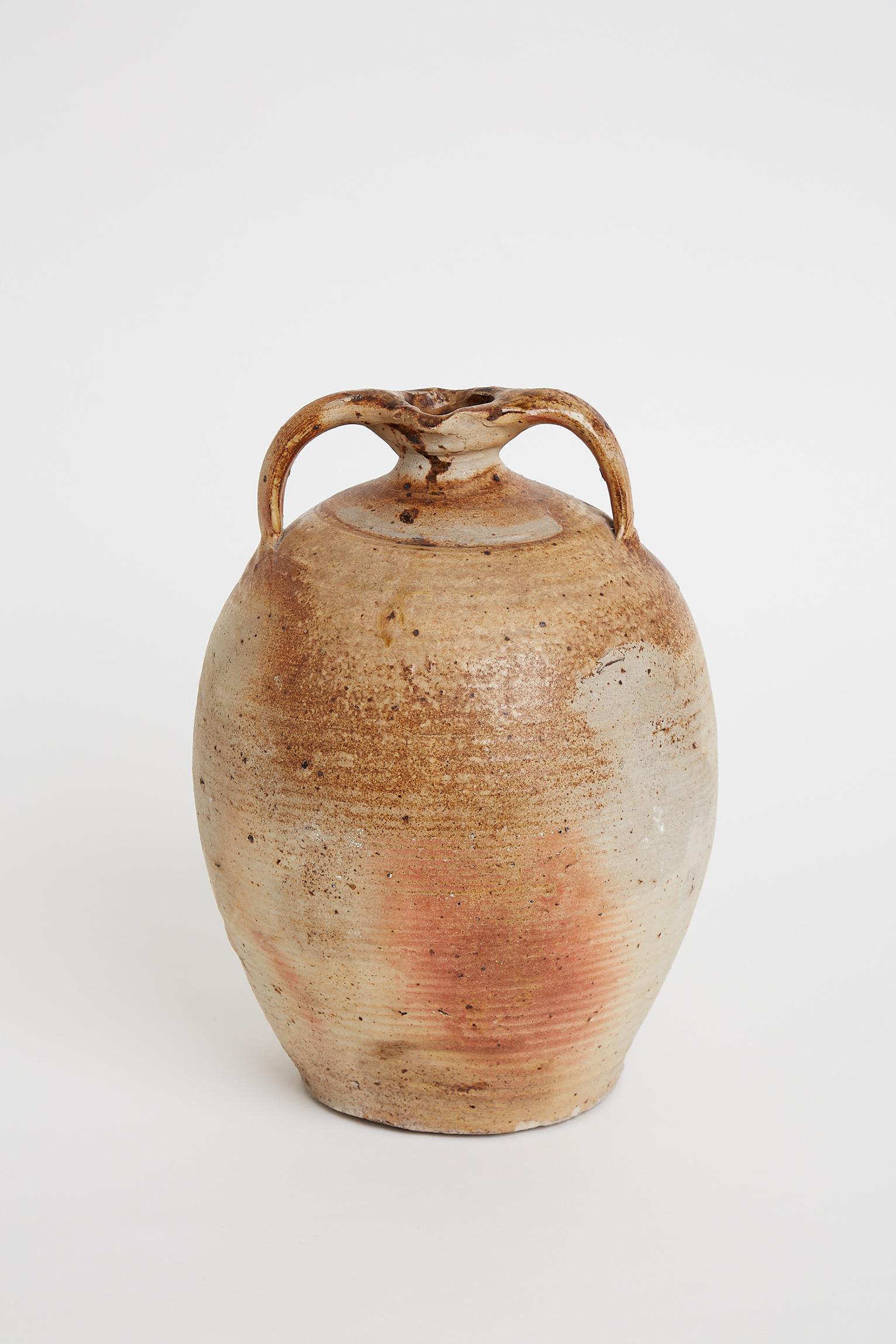A large grès de Puisaye stoneware 'bombonne' jar, elegantly shaped and with two handles, partially ash enameled, the surface superbly marked by the firing.
La Borne, Berry, France. 19th century, possibly earlier.