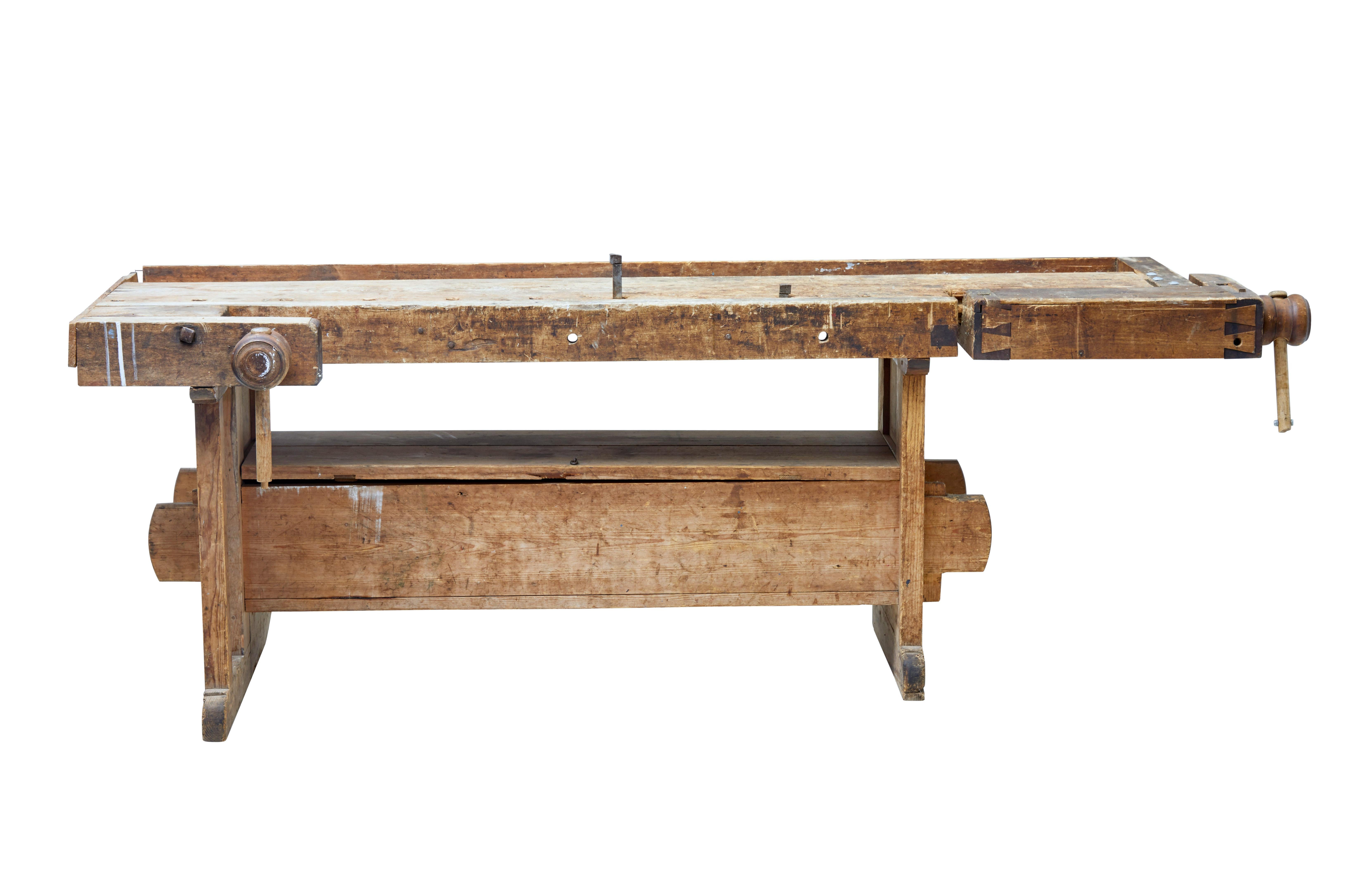 Here we offer a fine 19th century Swedish pine work bench, circa 1880.

Working double clamp on one end, and a threaded clamp to the front.

Obvious signs of use, but fully functional. Standing on trestle legs united by stretchers and held in