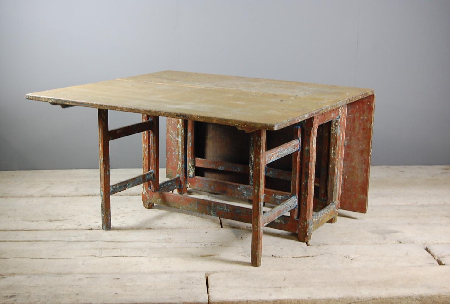 Large Swedish slagbord or drop-leaf table, dry scraped back through multiple layers of old paint. Pine construction. great space saver to be used as a dining table, side or console table with the leaves folded down, Sweden, circa 1820.