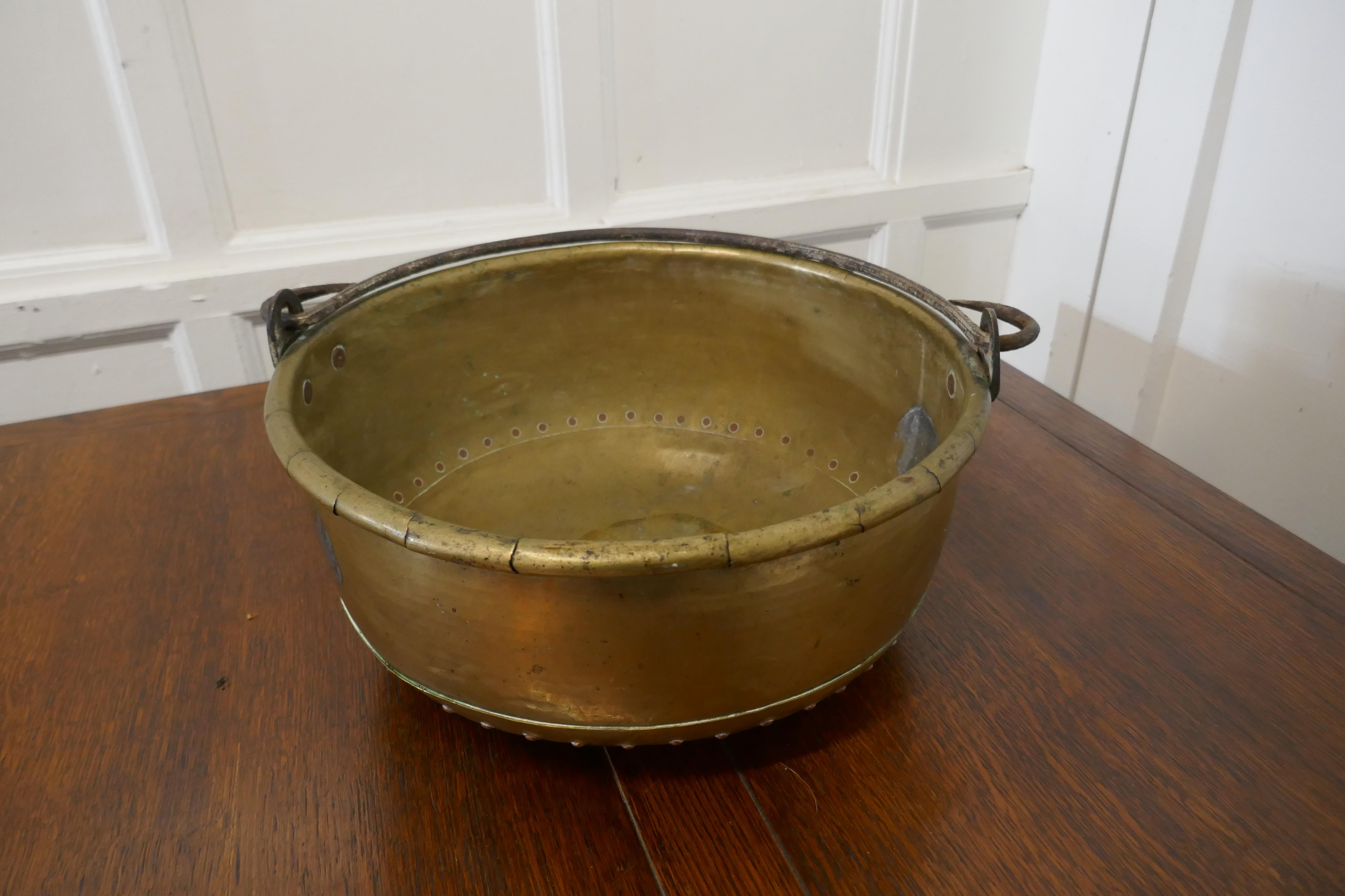 Large 19th century swing handled brass pan

This is a lovely looking Pan, the pan was obviously a very treasured piece, it has robust copper riveting and an iron swing handle
 
A pan of this type would have been used in jam making, for dairy