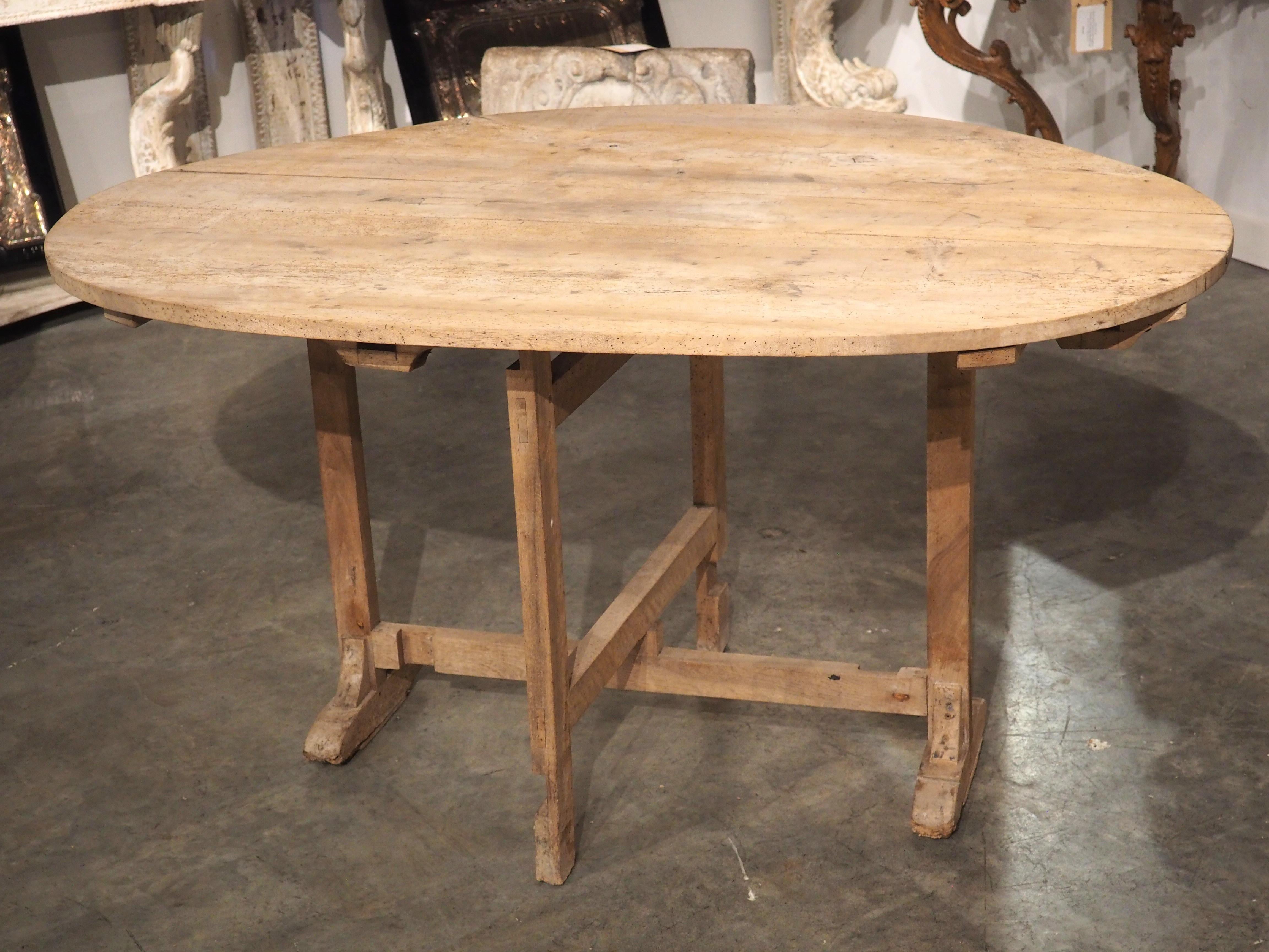 Larger than most tilt-top tables on the market, this wine-tasting table was most likely owned by a French vineyard in the 1800s. The large, ovate table can comfortably seat four or possibly even 6 people when in its upright position and the top