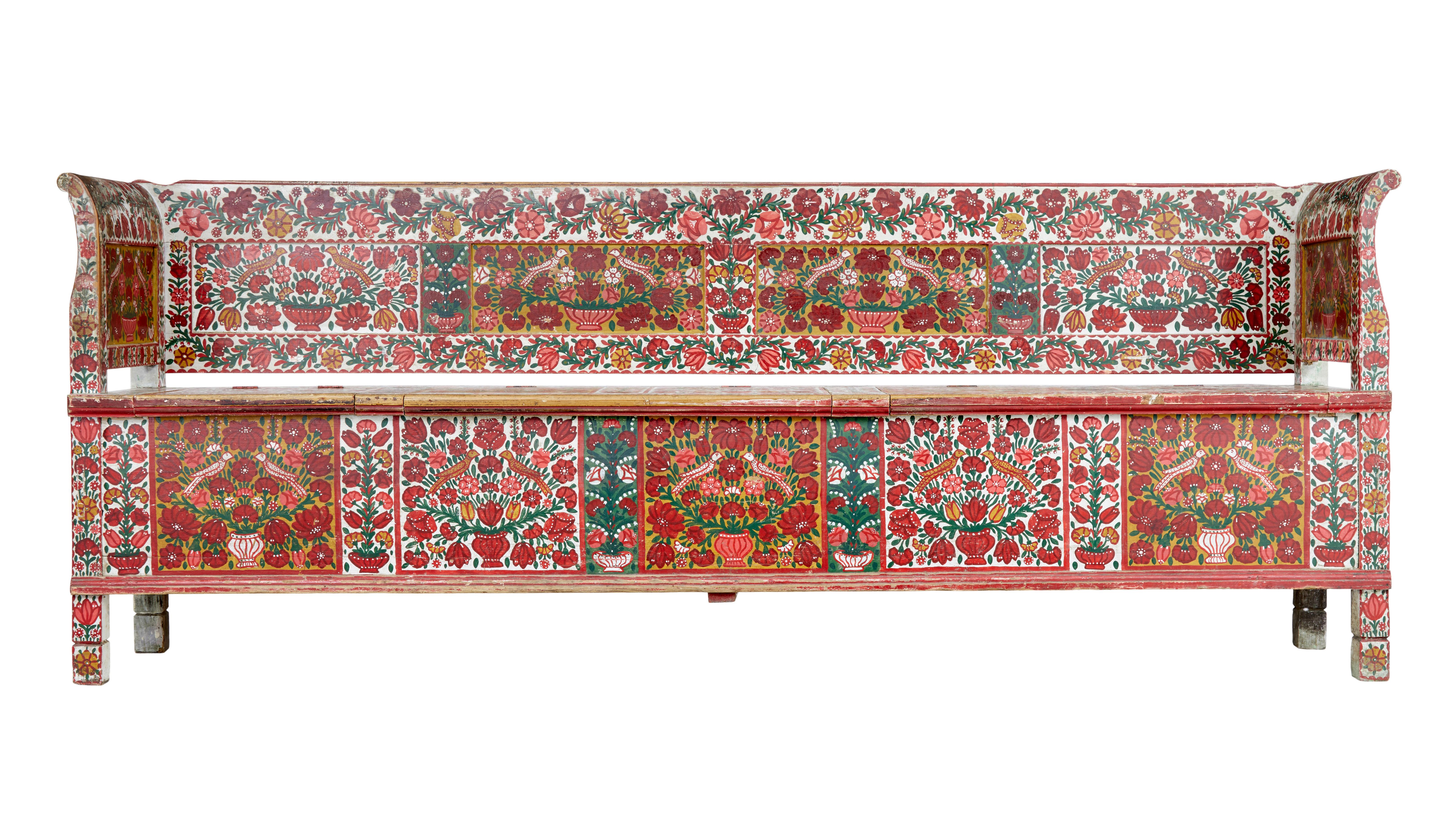 Stunning Swedish pine bench of large proportions circa 1860.

Original hand painted Swedish folk art decoration. Red and orange flowers spraying from an urn with birds.

3 light up panels in the seats which open up to reveal ample storage.

A