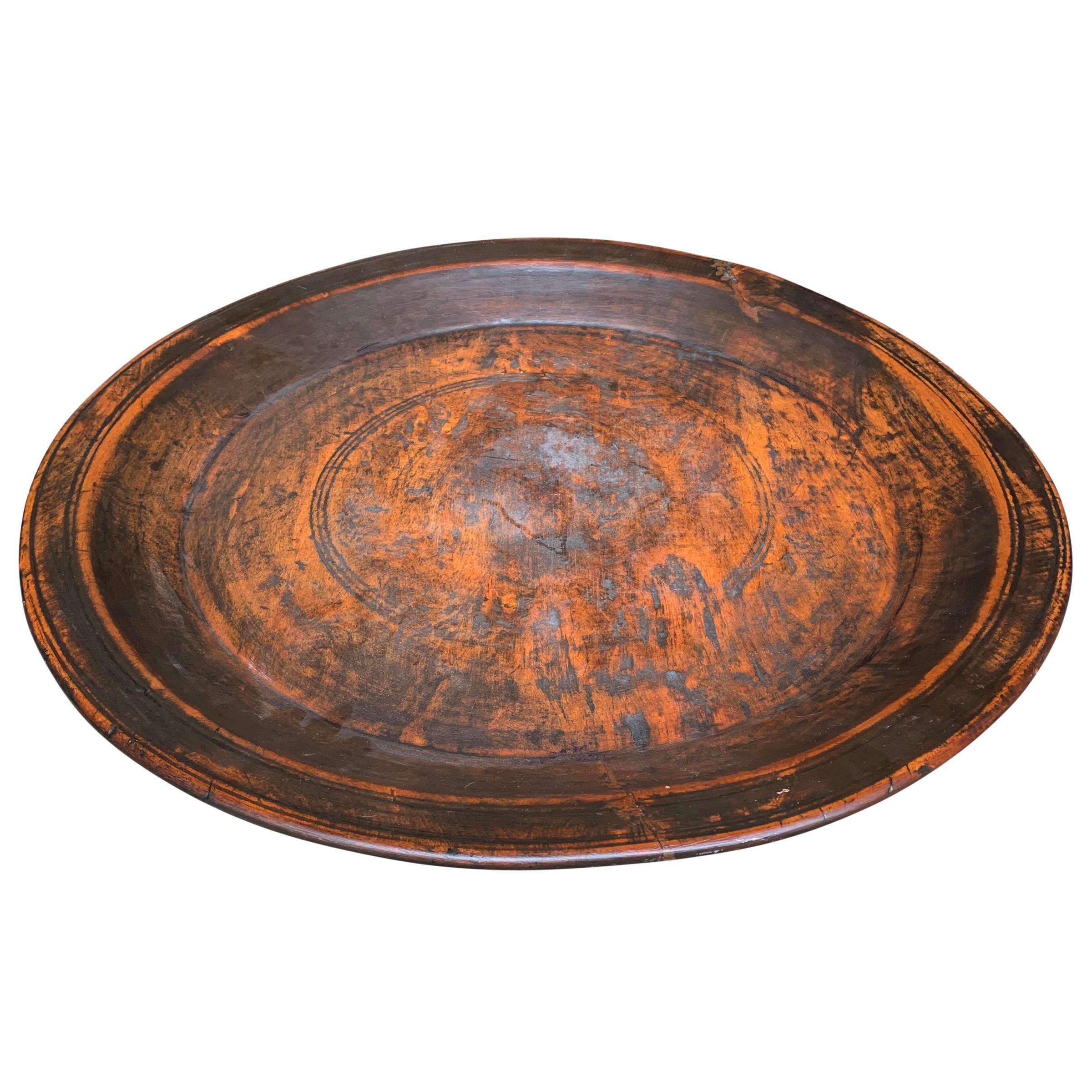 A wonderfully large 19th century turned wood tray with a beautiful patina, and a smooth finish. The reverse side shows several incised lines. Perfect for use as a catchall for mail, magazines, or any other myriad used.