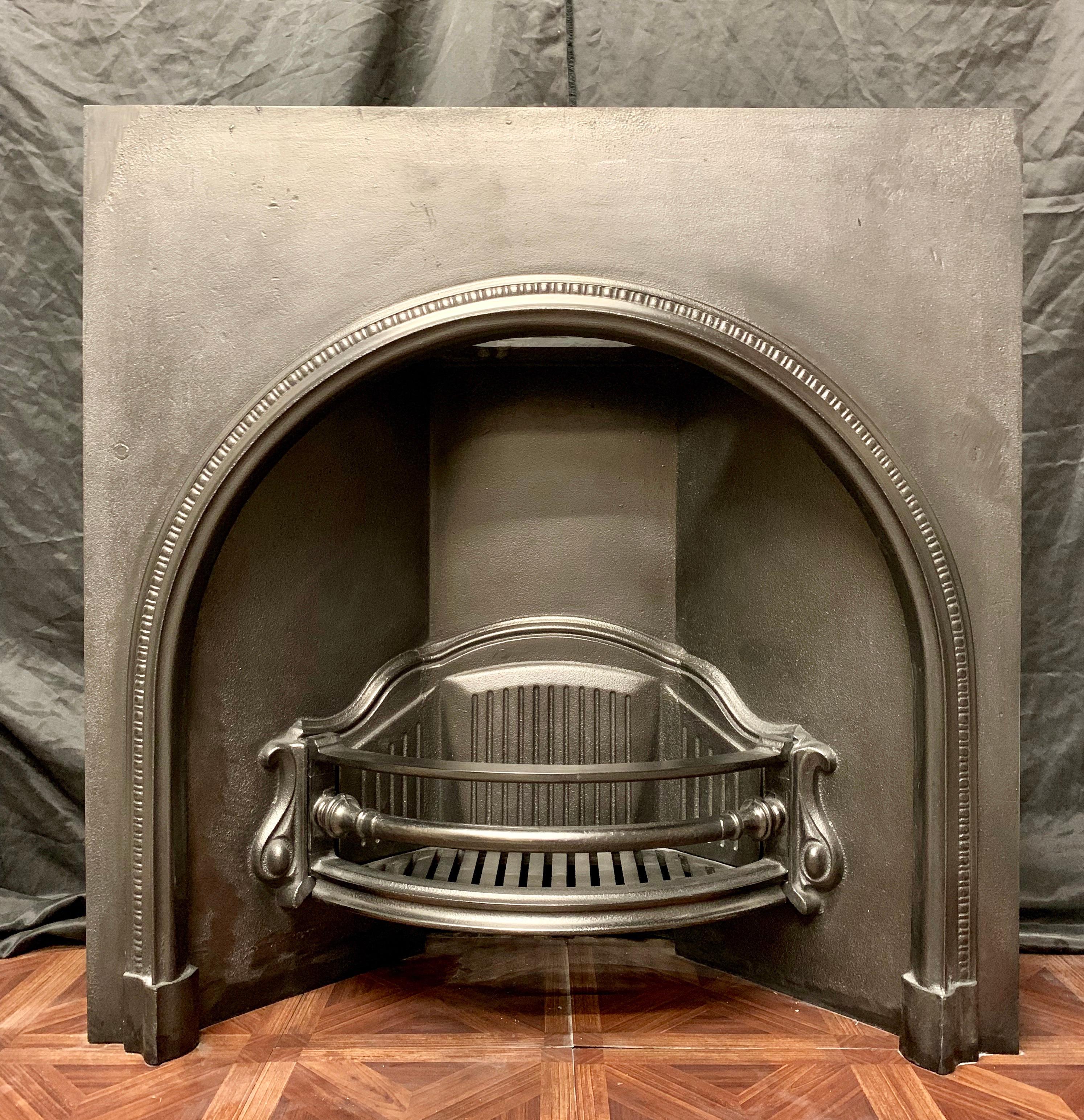 A large cast iron 19th century slow arched fireplace insert with its original grate, newly painted and graphite polished.
 