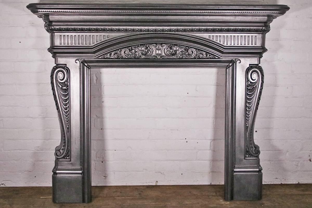 'The Dragons' a large and splendidly decorated late 19th century Victorian cast iron fire surround, with scrolling acanthus leaves giving excellent shape to the legs. To the center of the reeded frieze is an exquisitely cast applied panel depicting