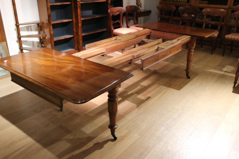 Beautiful impressive English mahogany dining room table in good original condition. The table has 3 (original) leaves that allow for different configurations. It is a sliding system so that you first pull the undercarriage apart so that 1 or 2